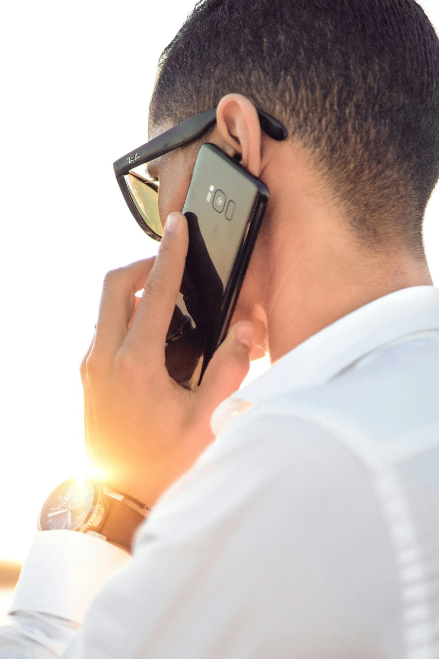 Homme de dos tenant un smartphone et passant un appel téléphonique