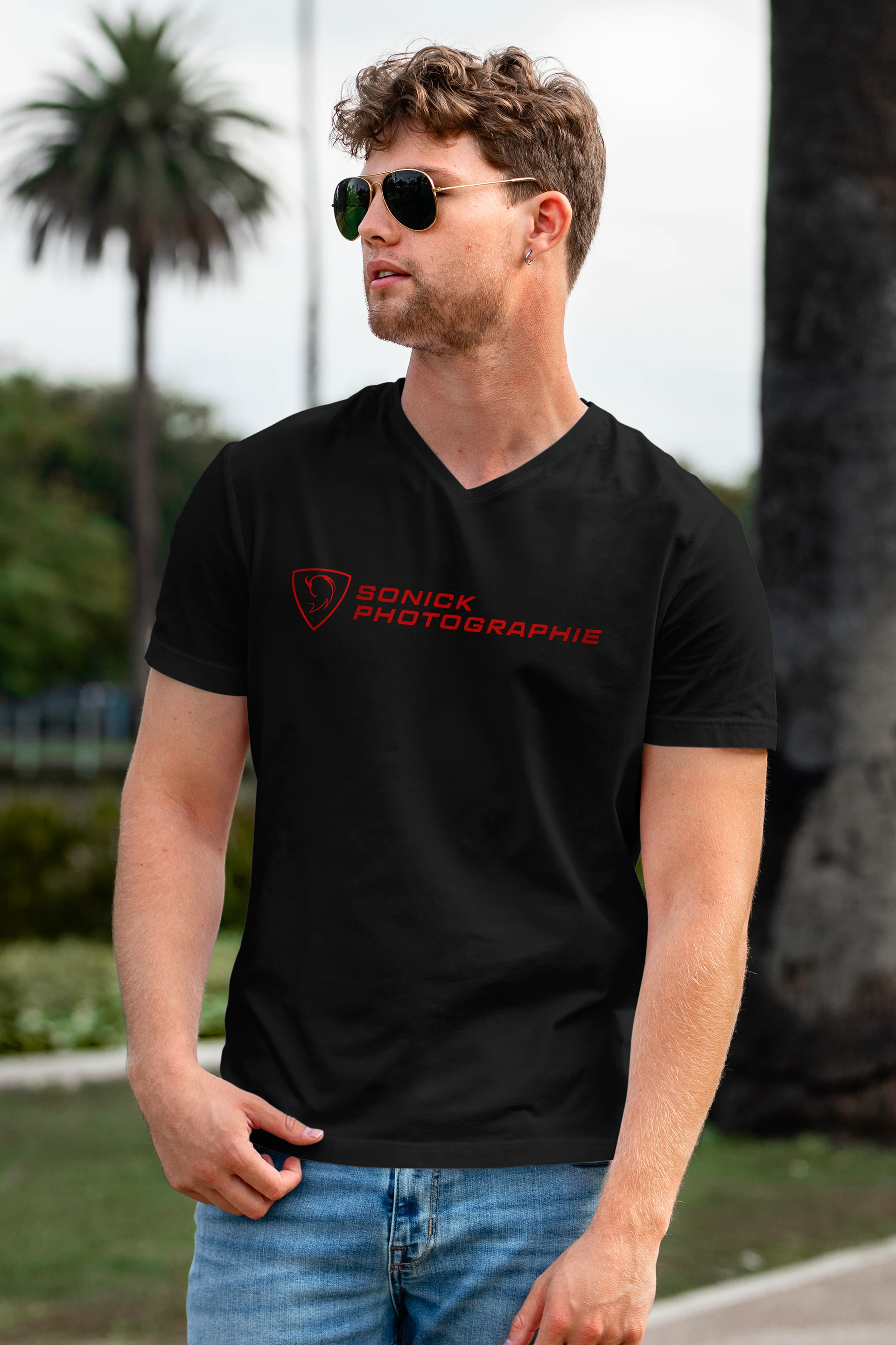 Homme blanc avec des lunettes de soleil regardant au loin et portant un t-shirt noir Sonick Photographie