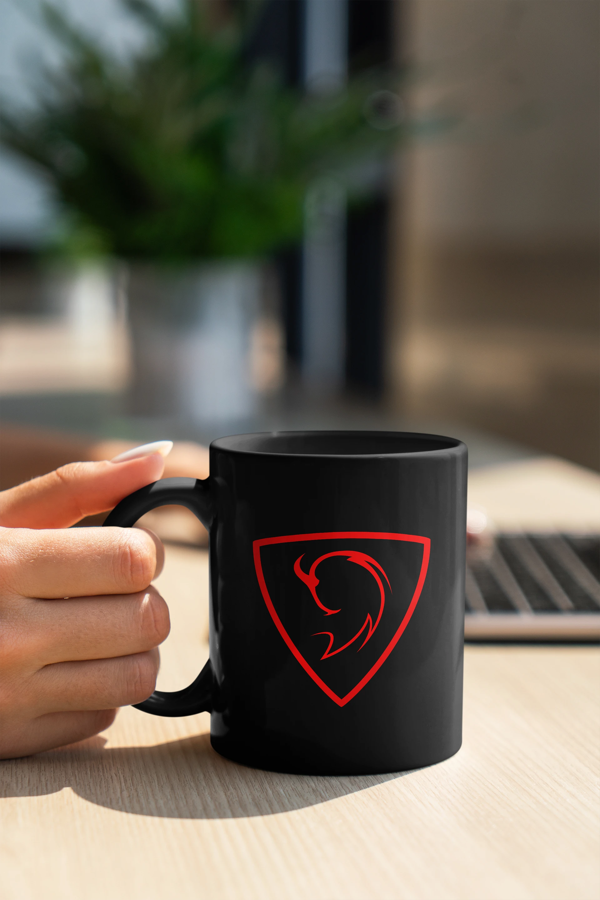 Main tenant une tasse mug noire avec le logo Sonick Photographie rouge