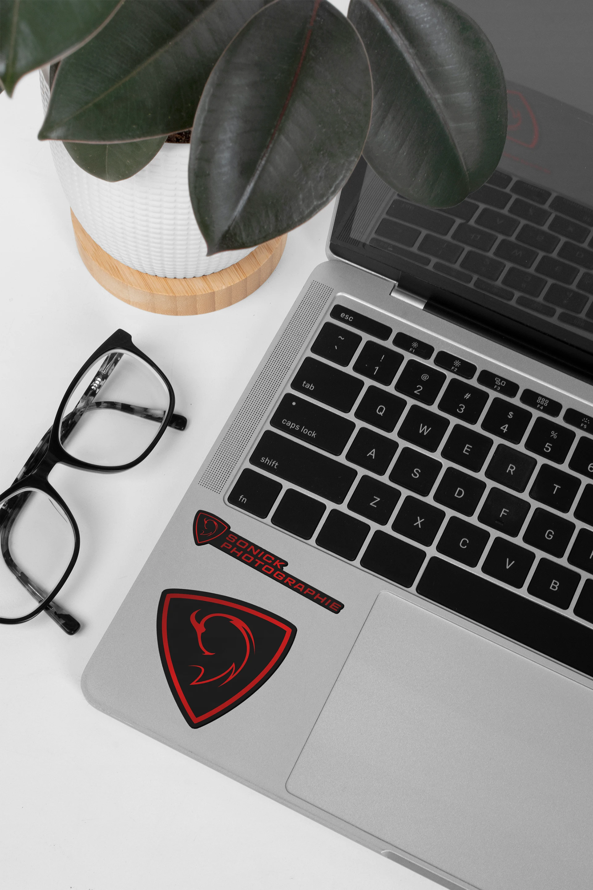 Ordinateur portable gris avec deux stickers Sonick Photographie rouges