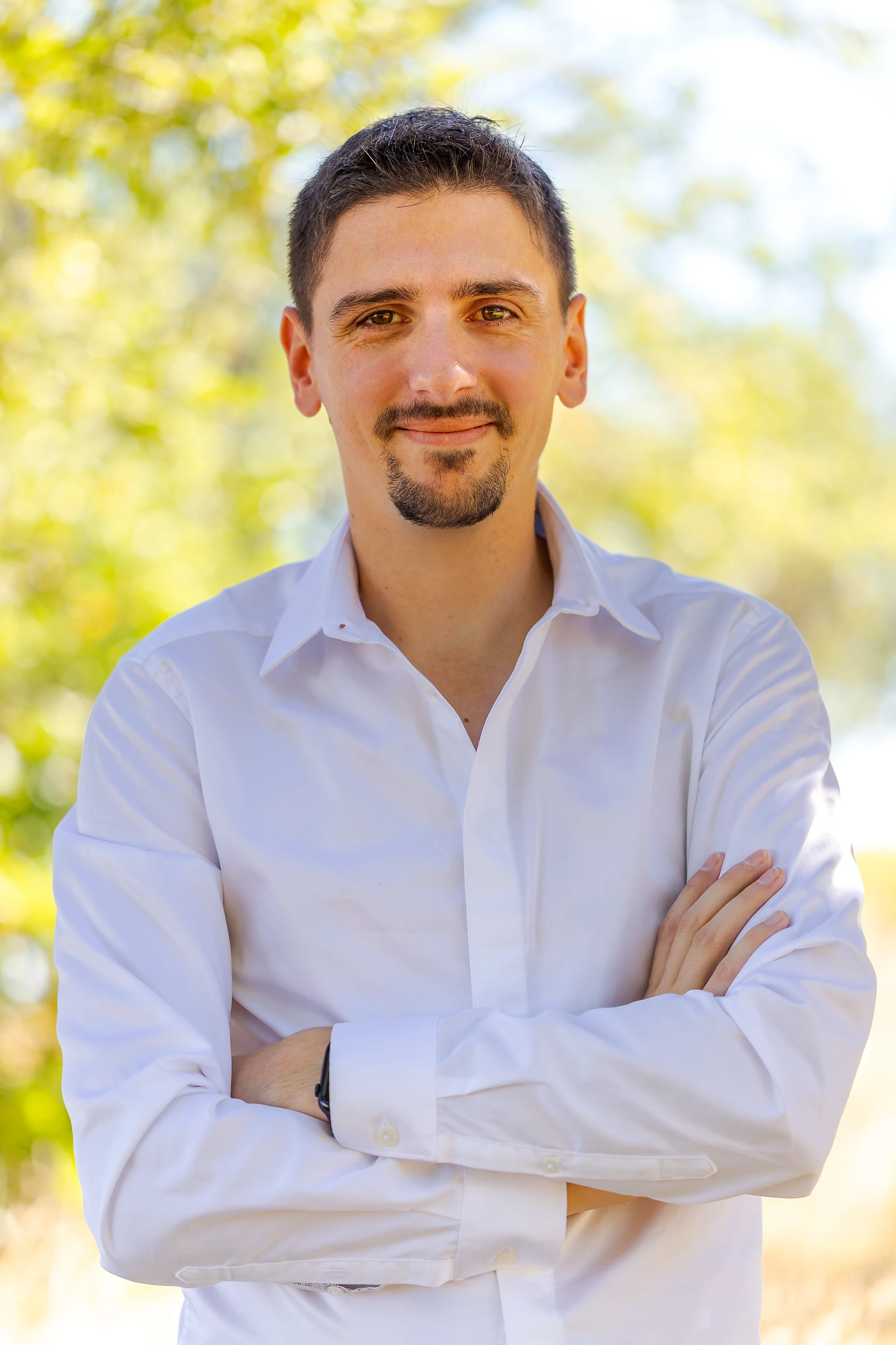 Yannick Soler avec une chemise blanche sur fond naturel