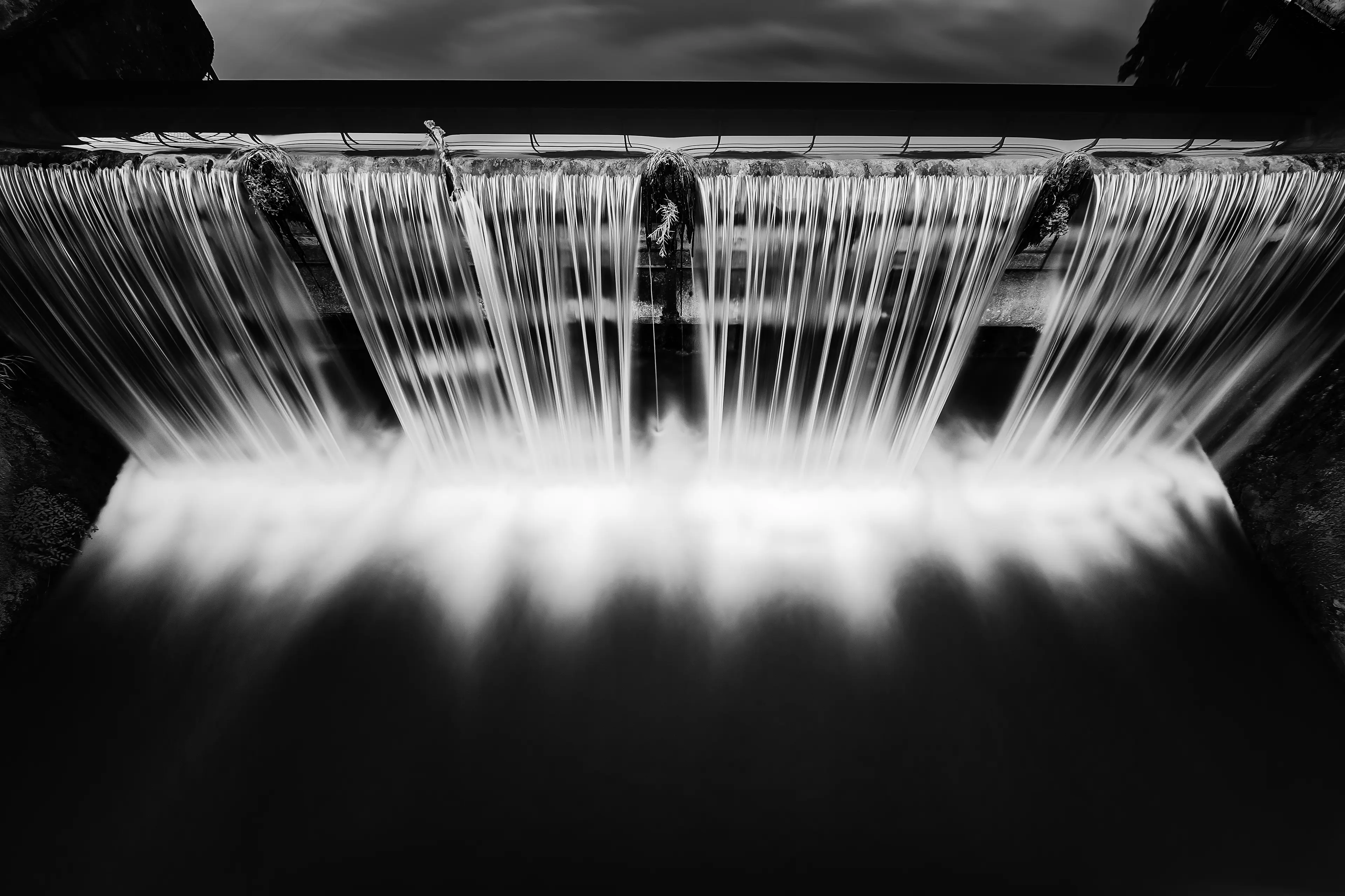 Pose longue d'une cascade d'eau du lac Kir à Dijon en noir et blanc