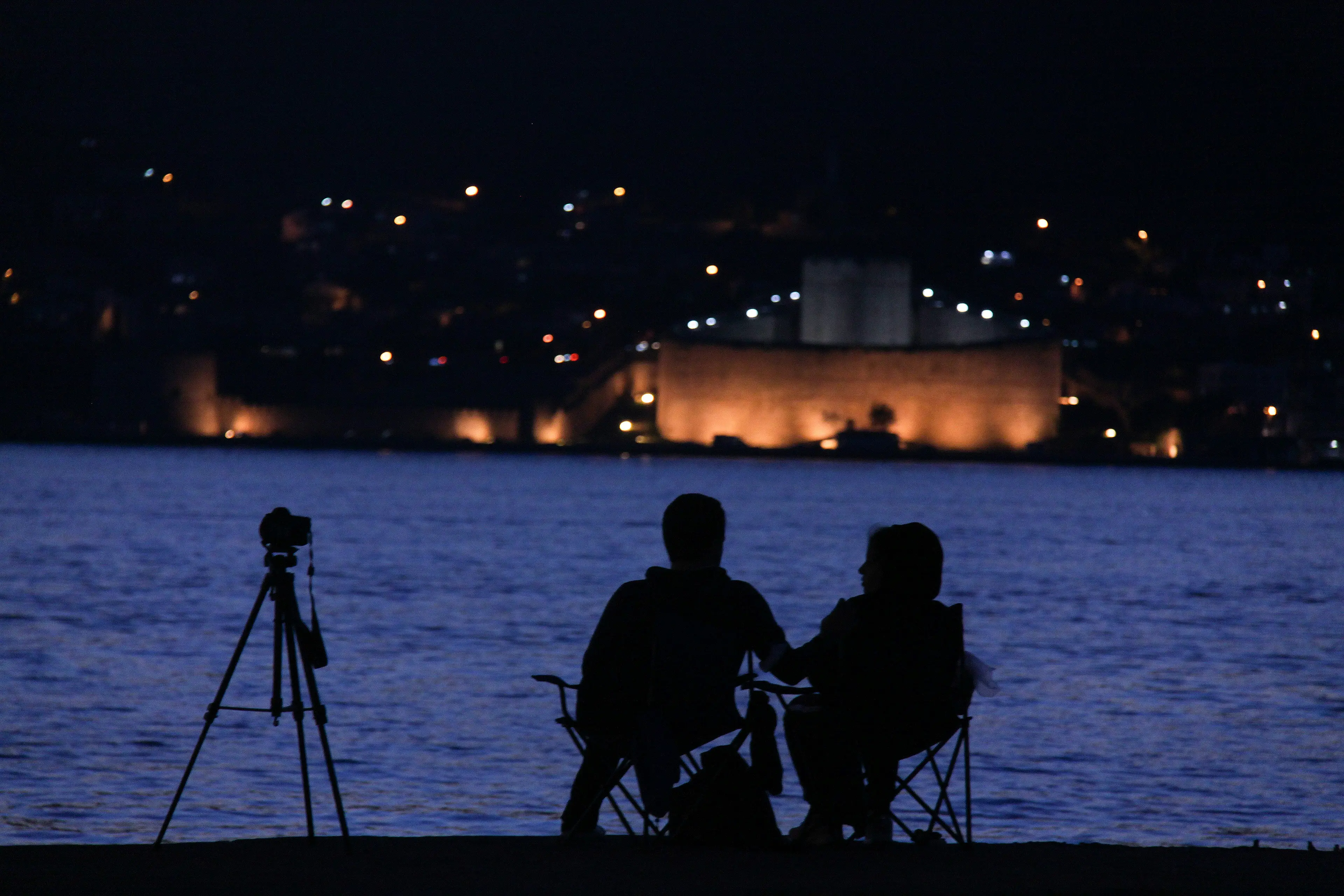 Couple au bord de l'eau avec un appareil photo sur trépied