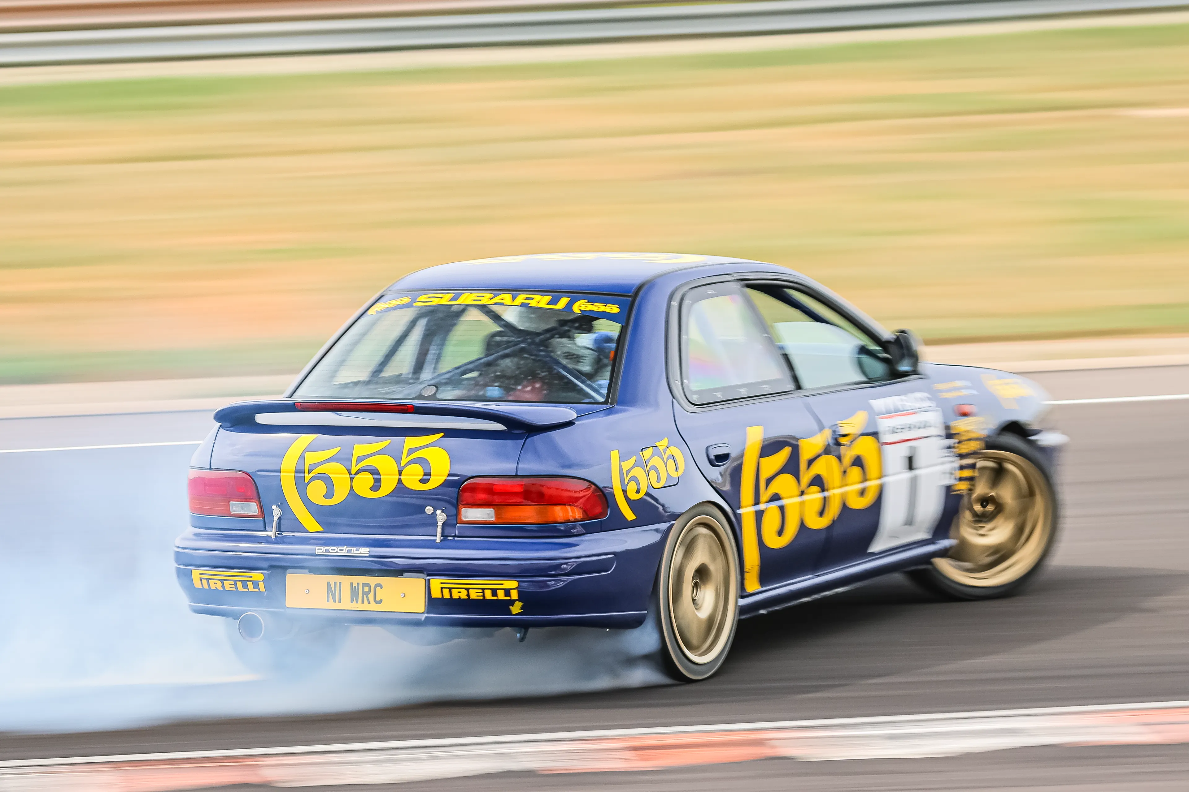 Subaru Impreza bleue avec déco 555 en dérapage sur le circuit de Lédenon
