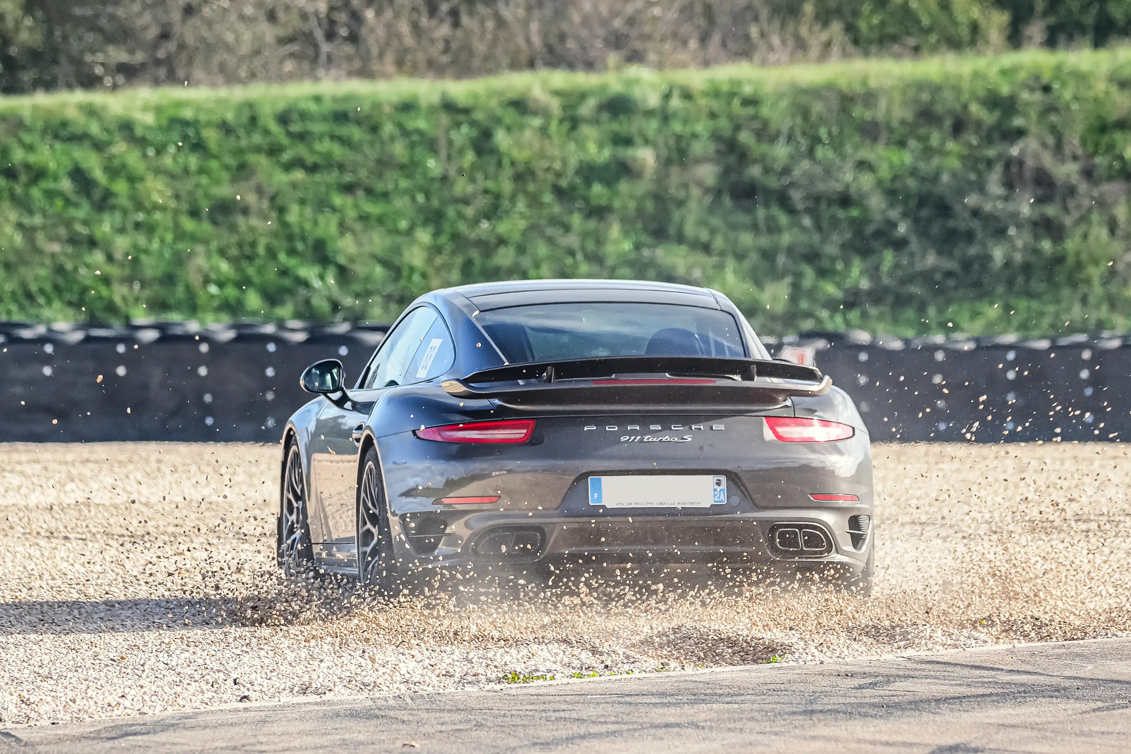 Porsche 911 991 Turbo S marron dans les graviers sur le circuit de Dijon-Prenois