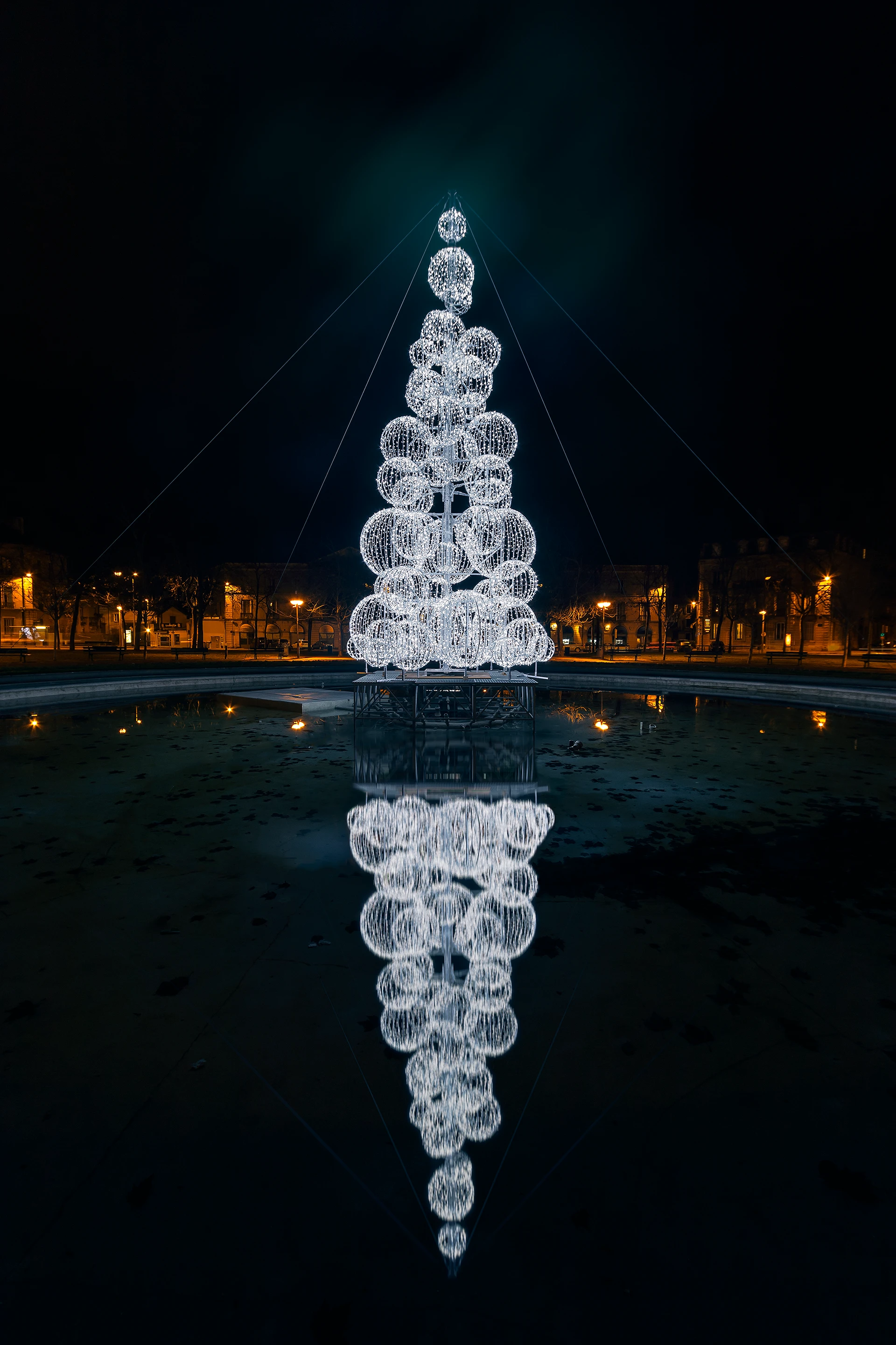 Sapin de Noël lumineux et son reflet dans la fontaine de la place Wilson à Dijon, en Côte d'Or