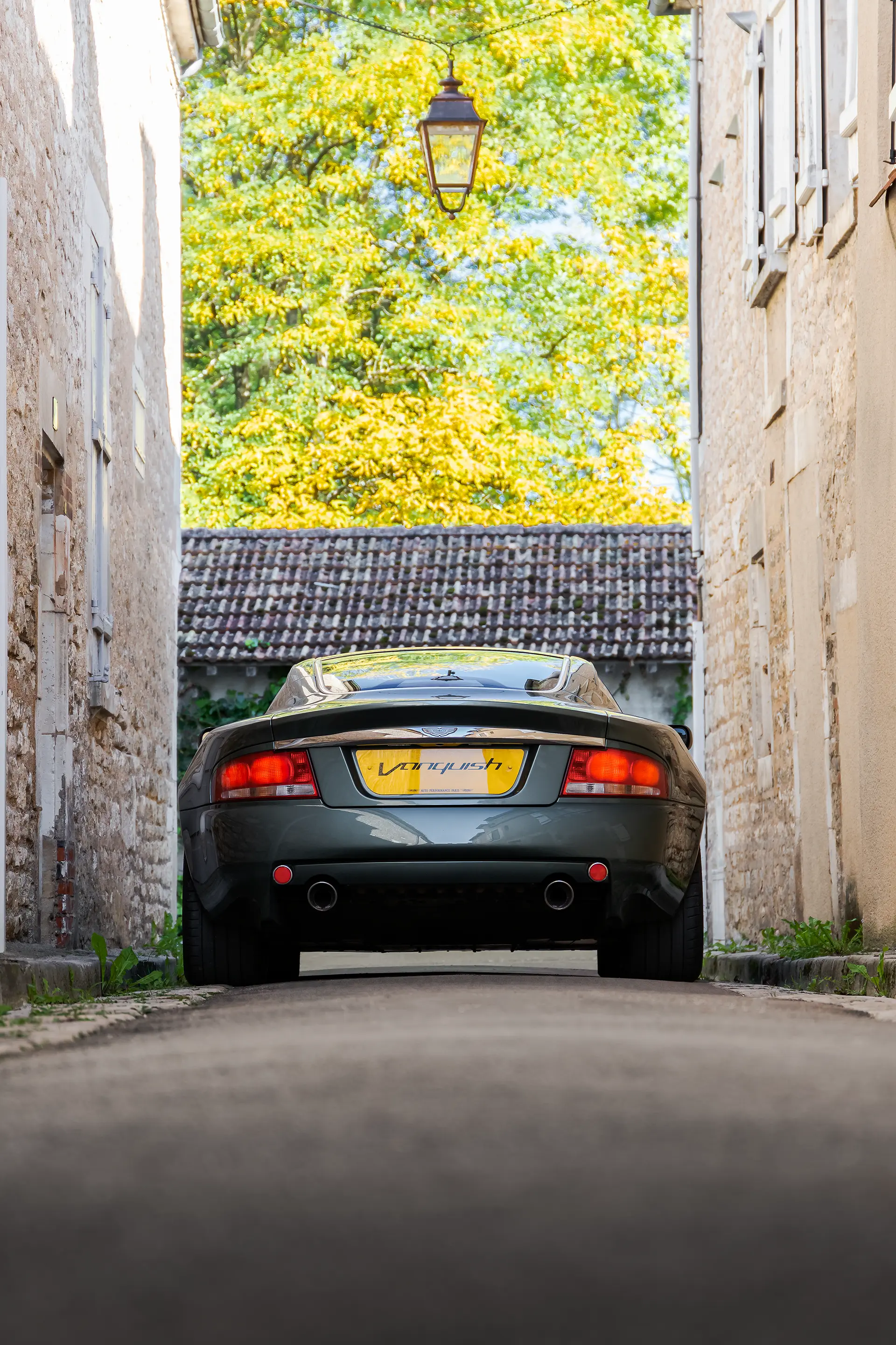 Arrière d'une Aston Martin Vanquish verte dans une ruelle étroite