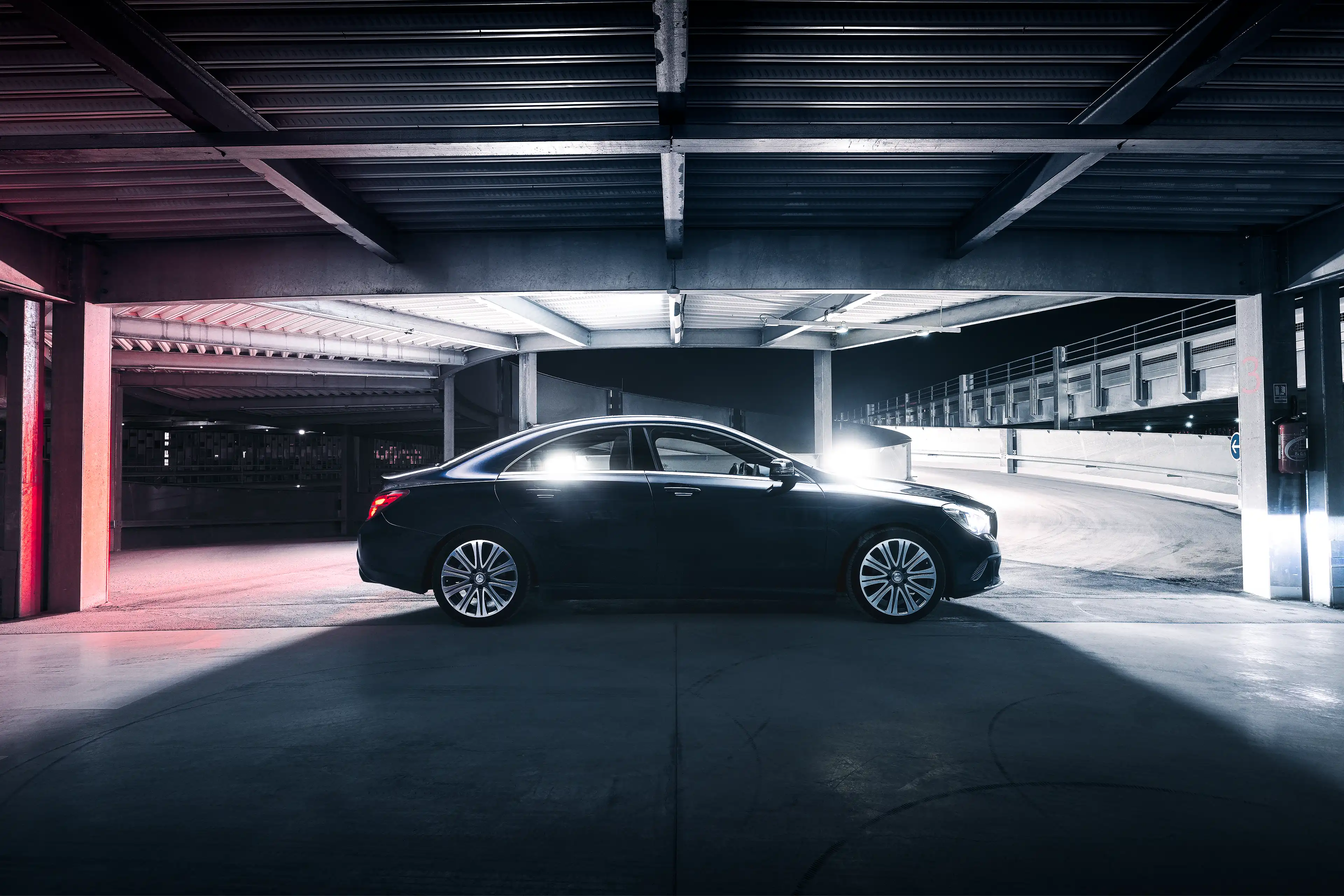 Mercedes CLA bleu foncée de profil de nuit dans un parking en light painting