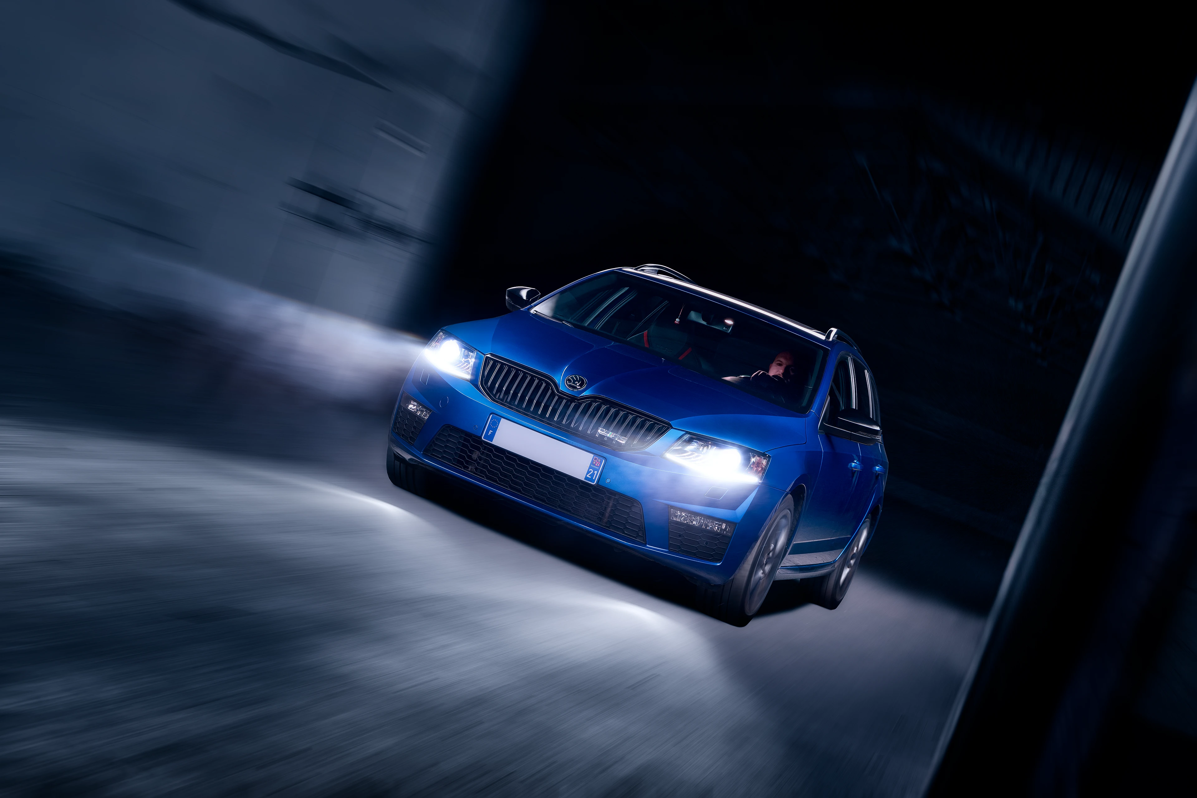 Skoda Octavia VRS break bleue de 3/4 avant en light painting roulant dans un entrepôt sombre