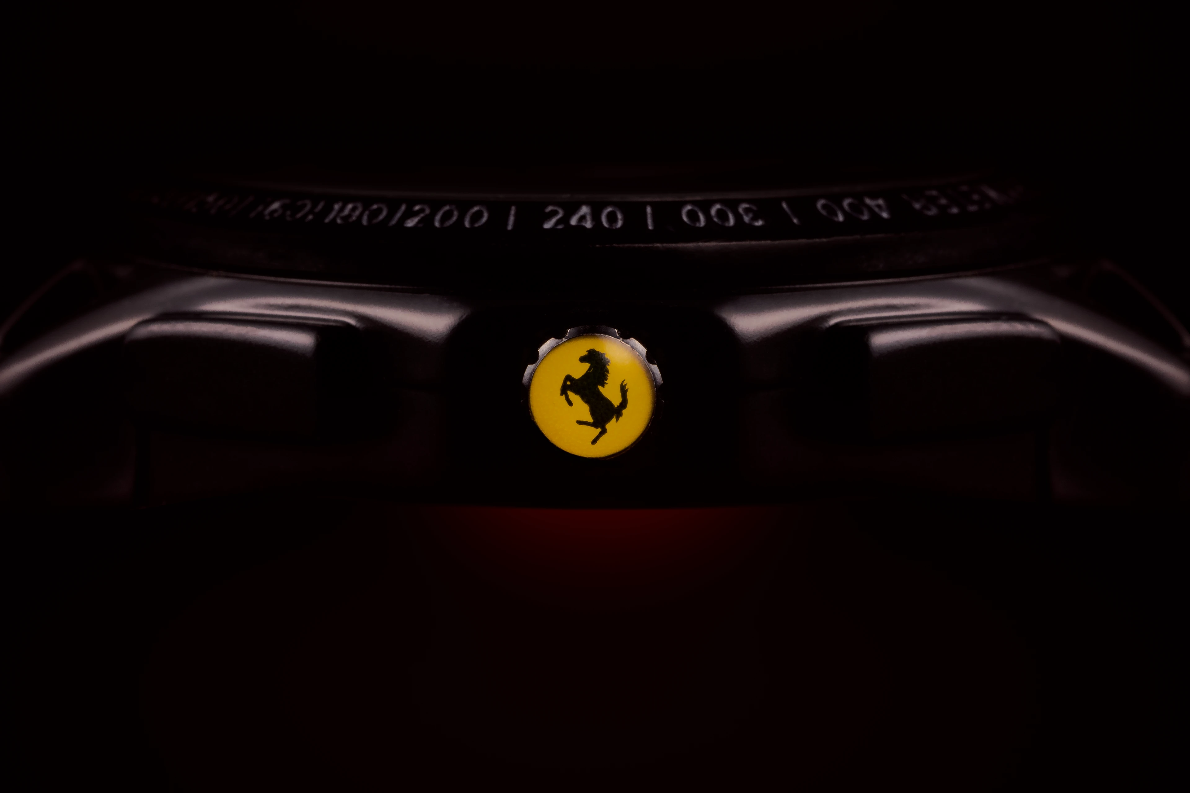 Bouton de réglage de montre Ferrari avec le cheval cabré sur fond jaune