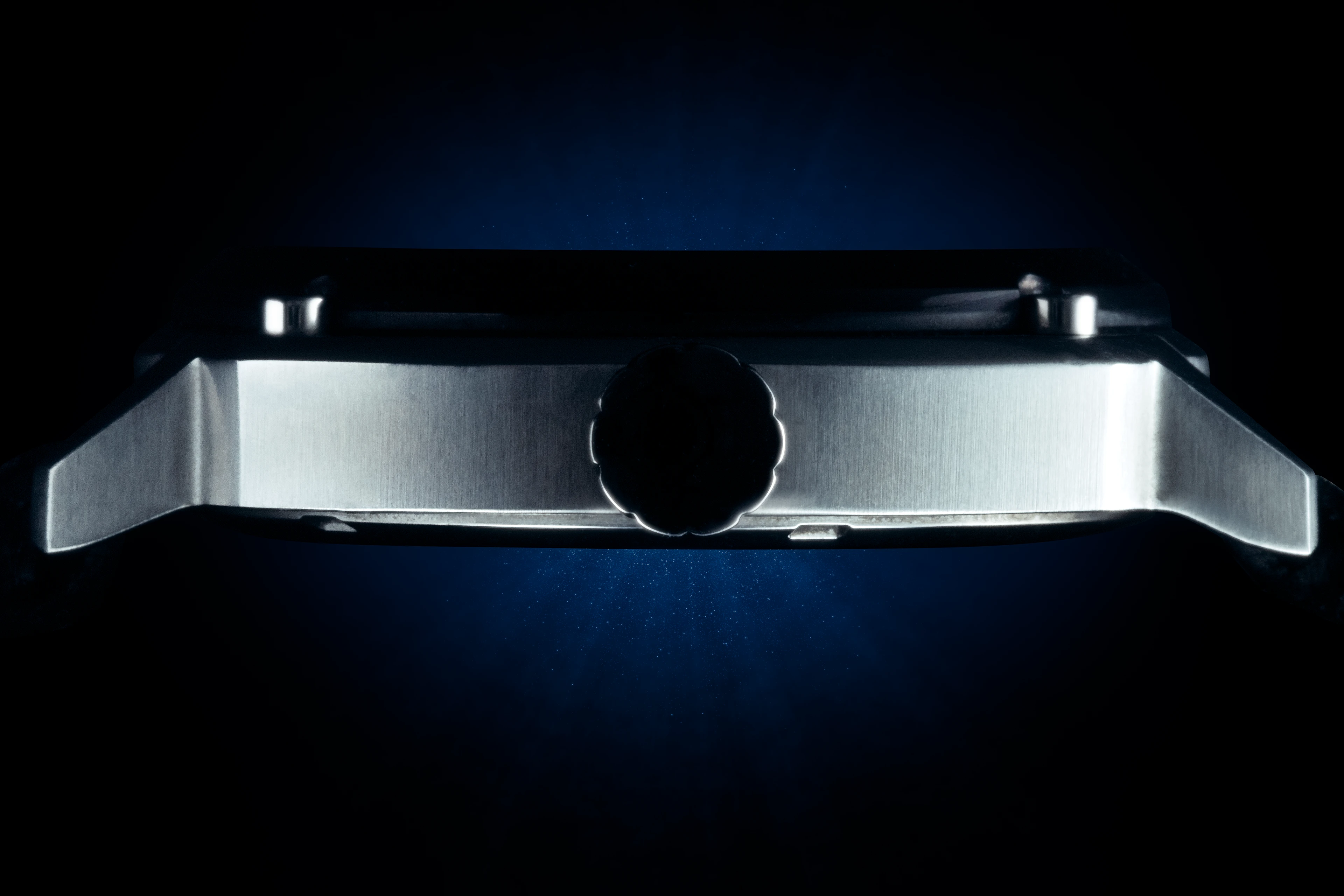 Bouton de réglage d'une montre DMC DeLorean sur fond noir et bleu