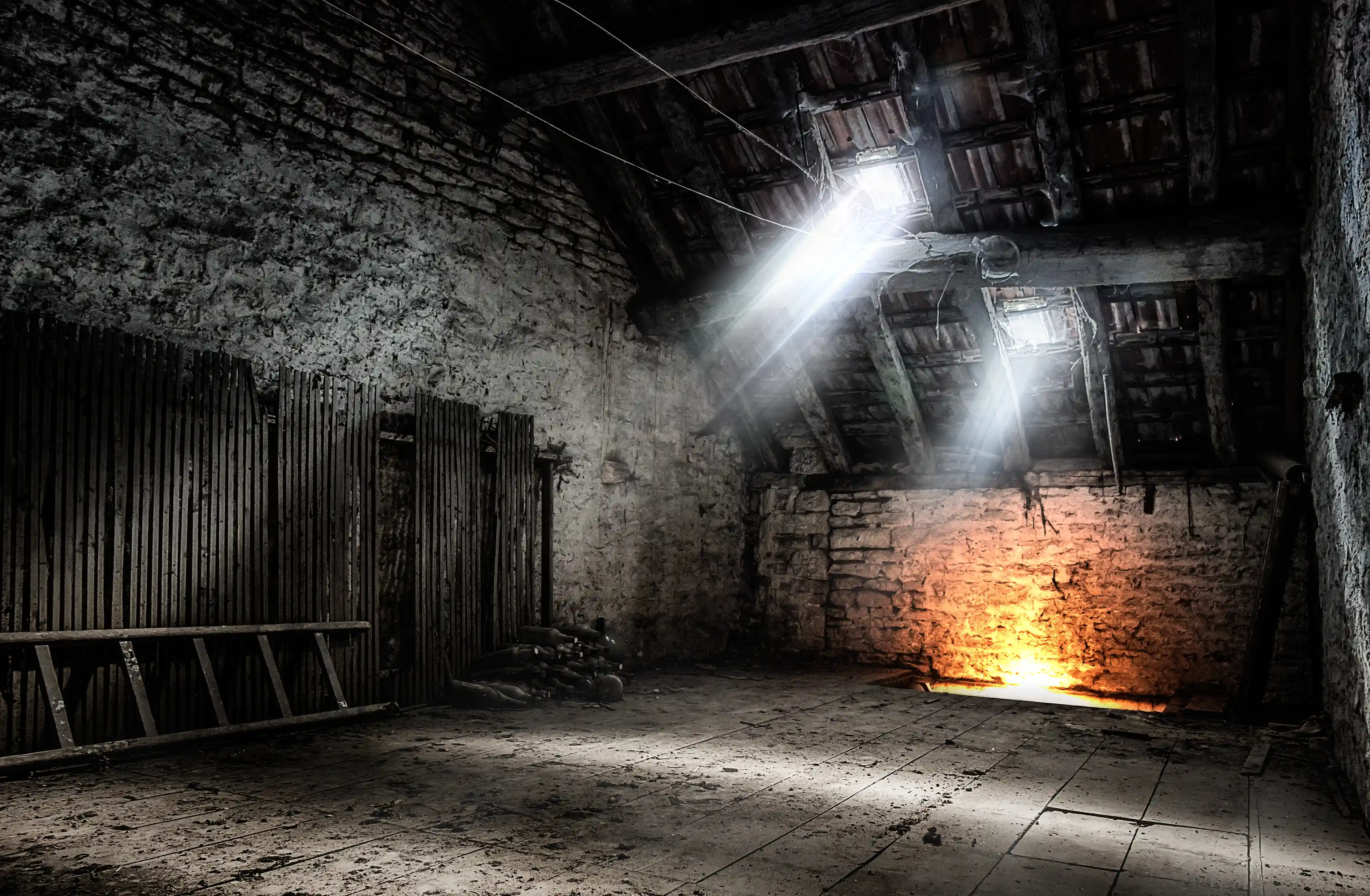 Photo urbex d'un grenier sombre où la lumière passe par le toit avec une source de chaleur sous le plancher