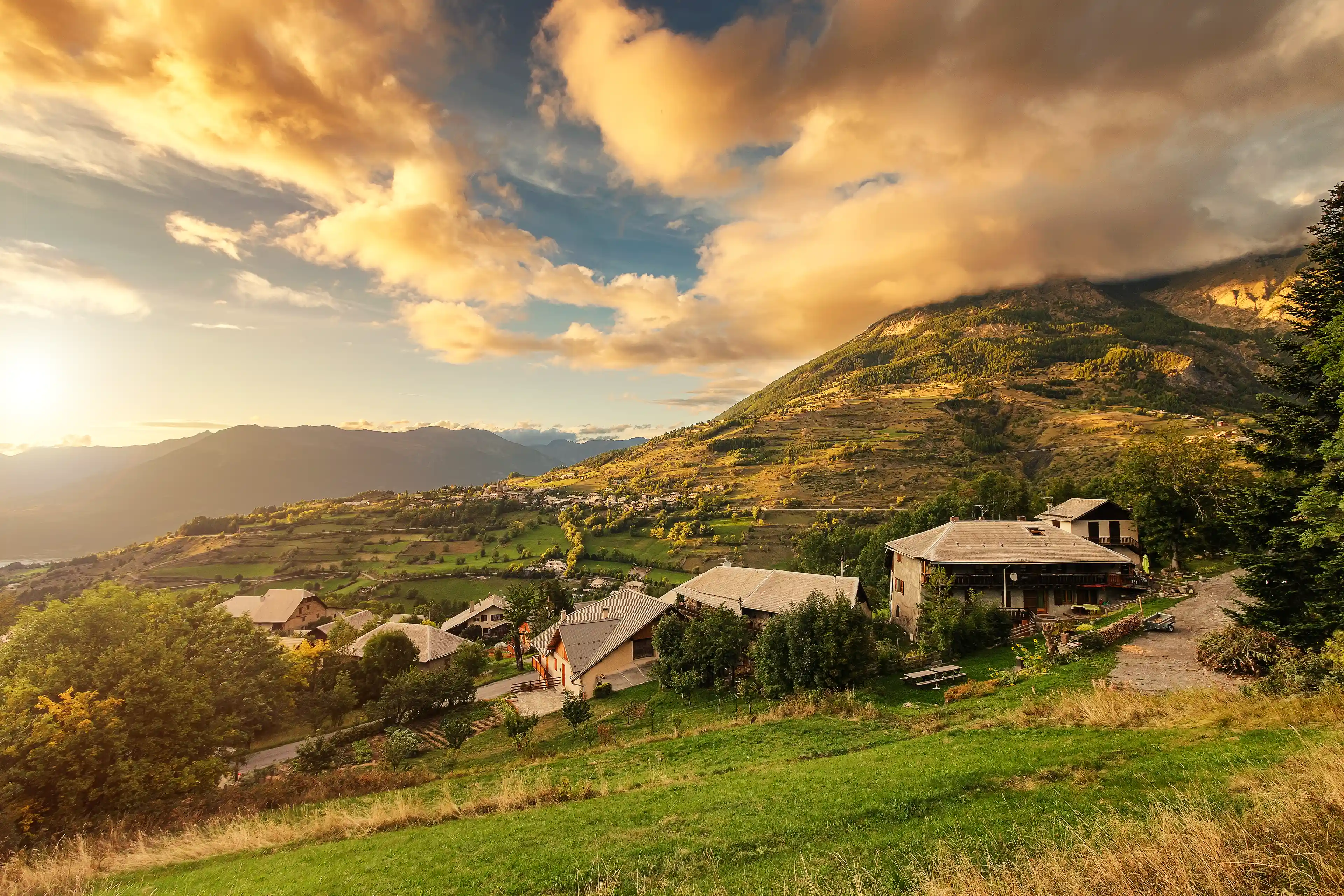 Coucher de soleil nuageux dans les montagnes des Hautes-Alpes avec des habitations