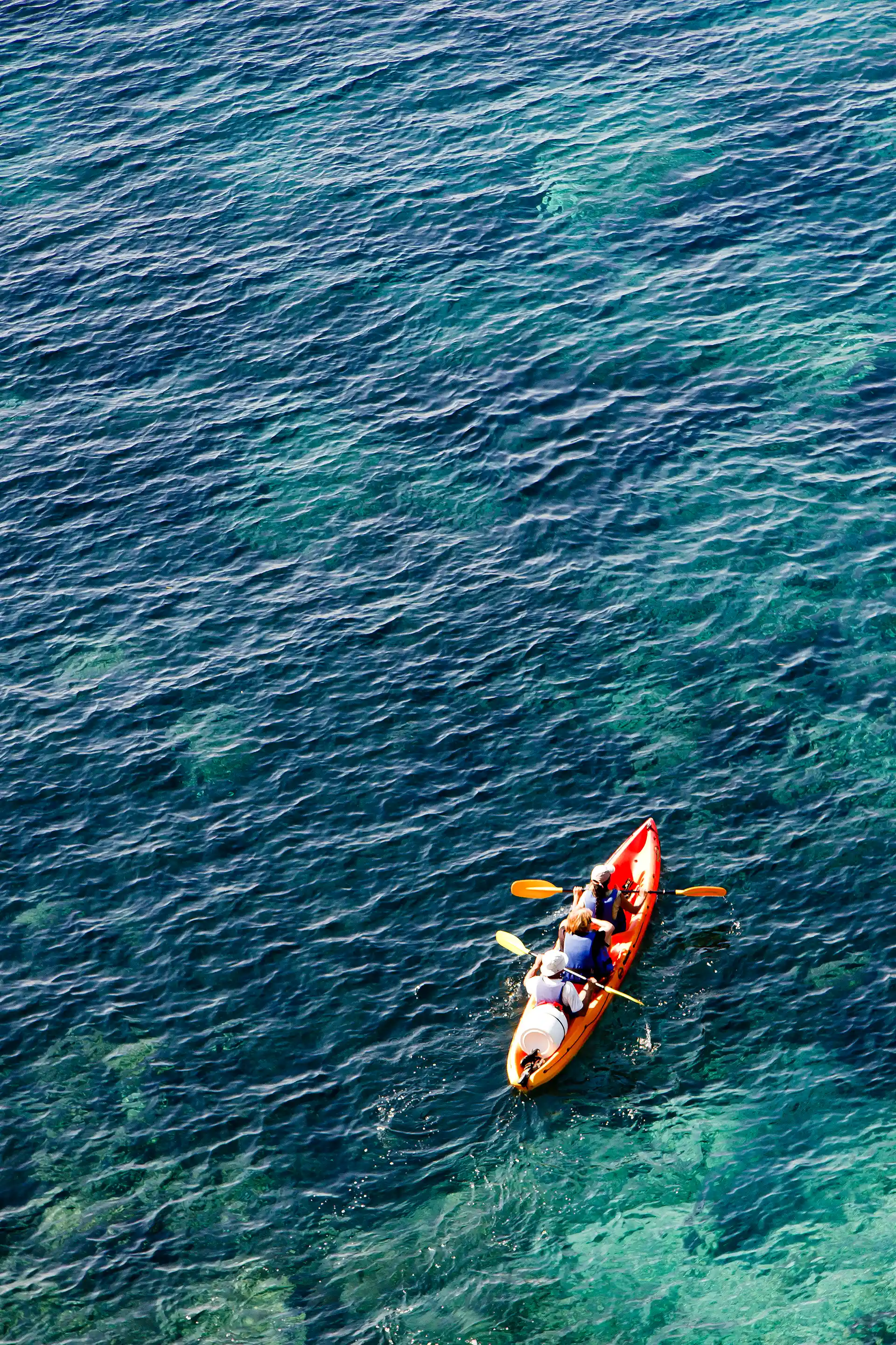 Deux personnes dans un canoë naviguant sur une eau turquoise