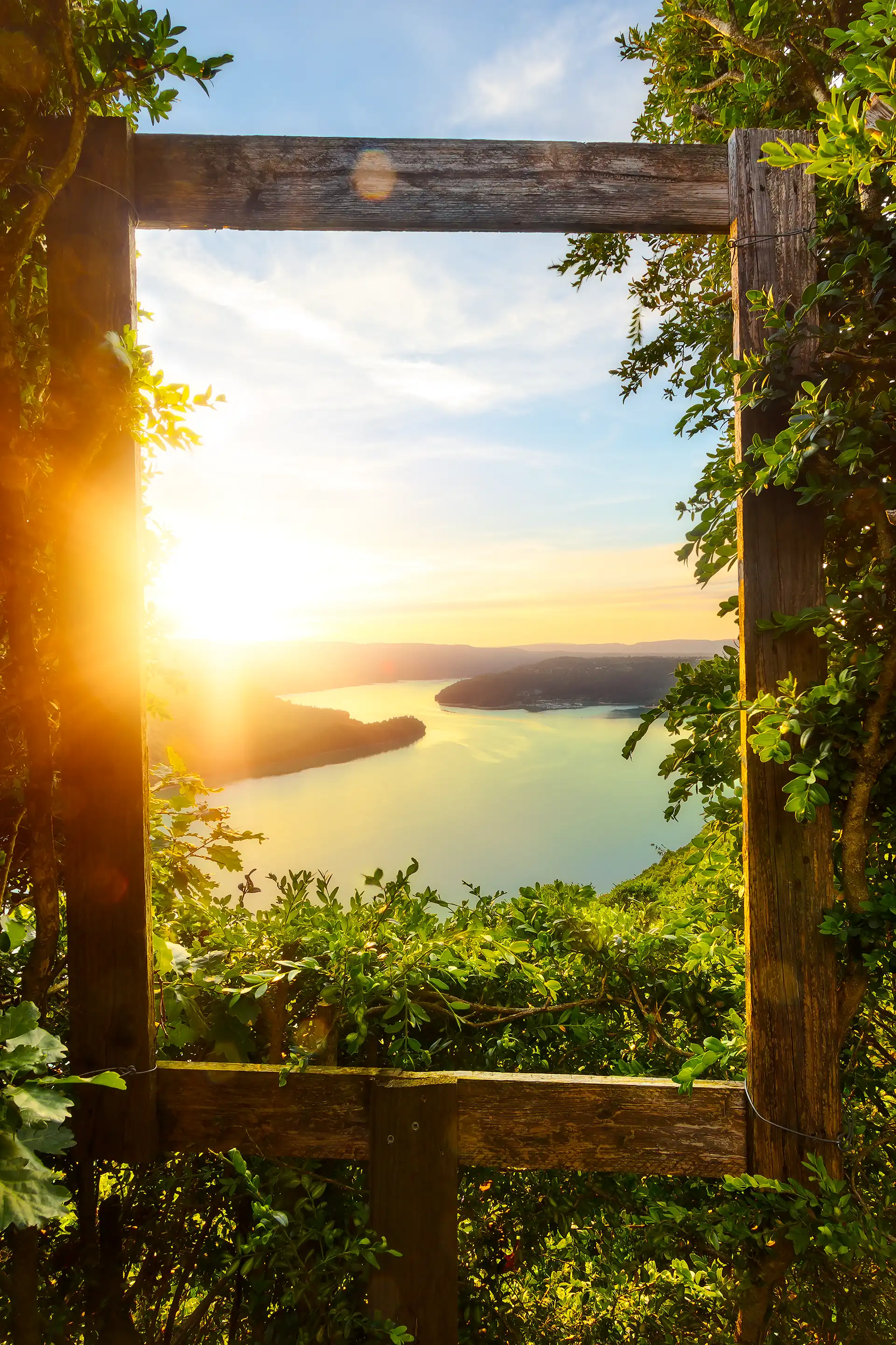 Cadre en bois laissant apparaître le lac de Vouglans dans le Jura au coucher du soleil