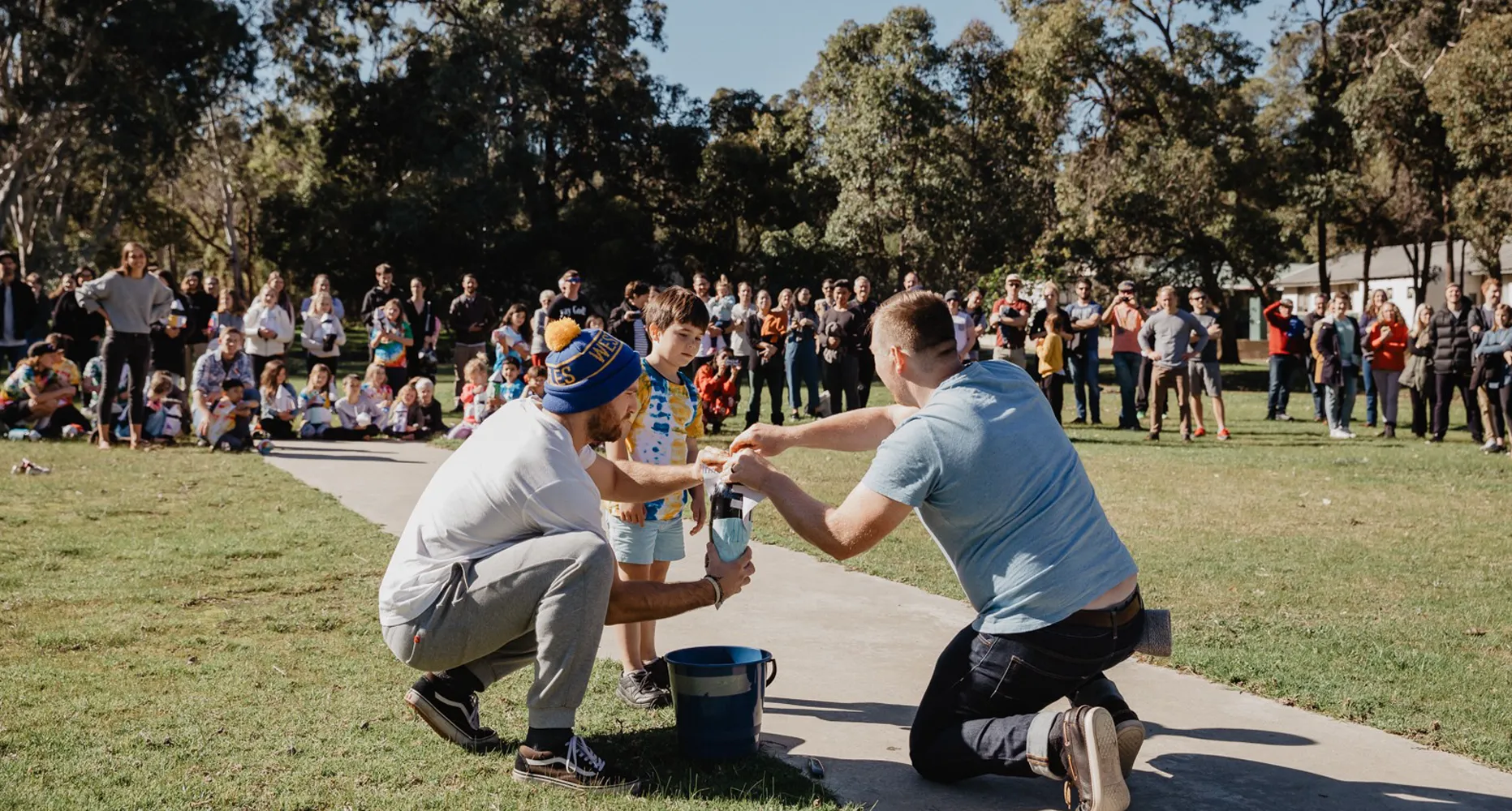 A large group of people playing a game outdoors.