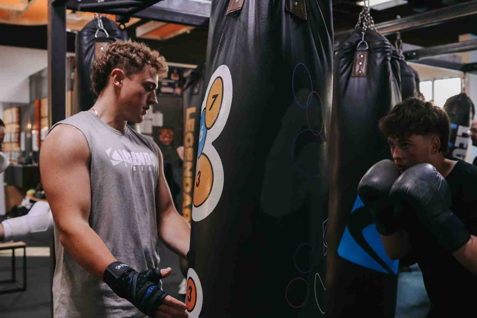 A boxer powerfully hitting a heavy bag with a cross, demonstrating full body engagement. - boxing skills for beginners