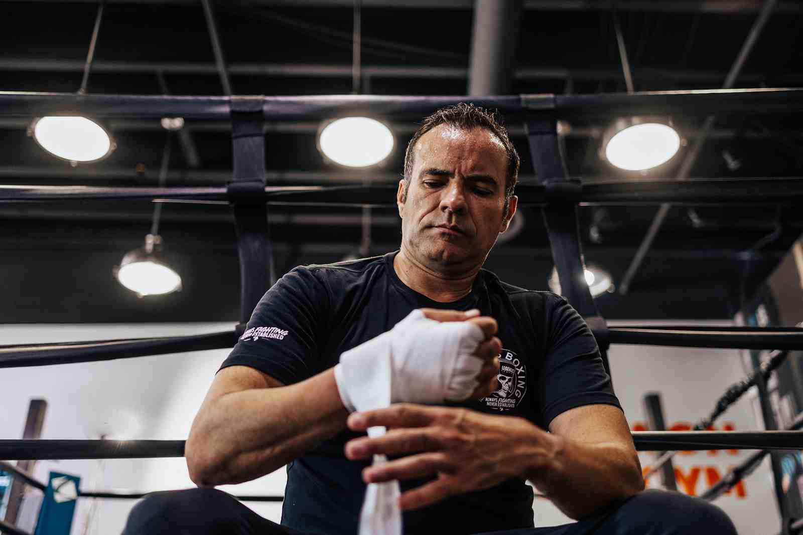 A person wrapping their hands with boxing wraps before a workout, symbolizing preparation and dedication - boxing gym utah county