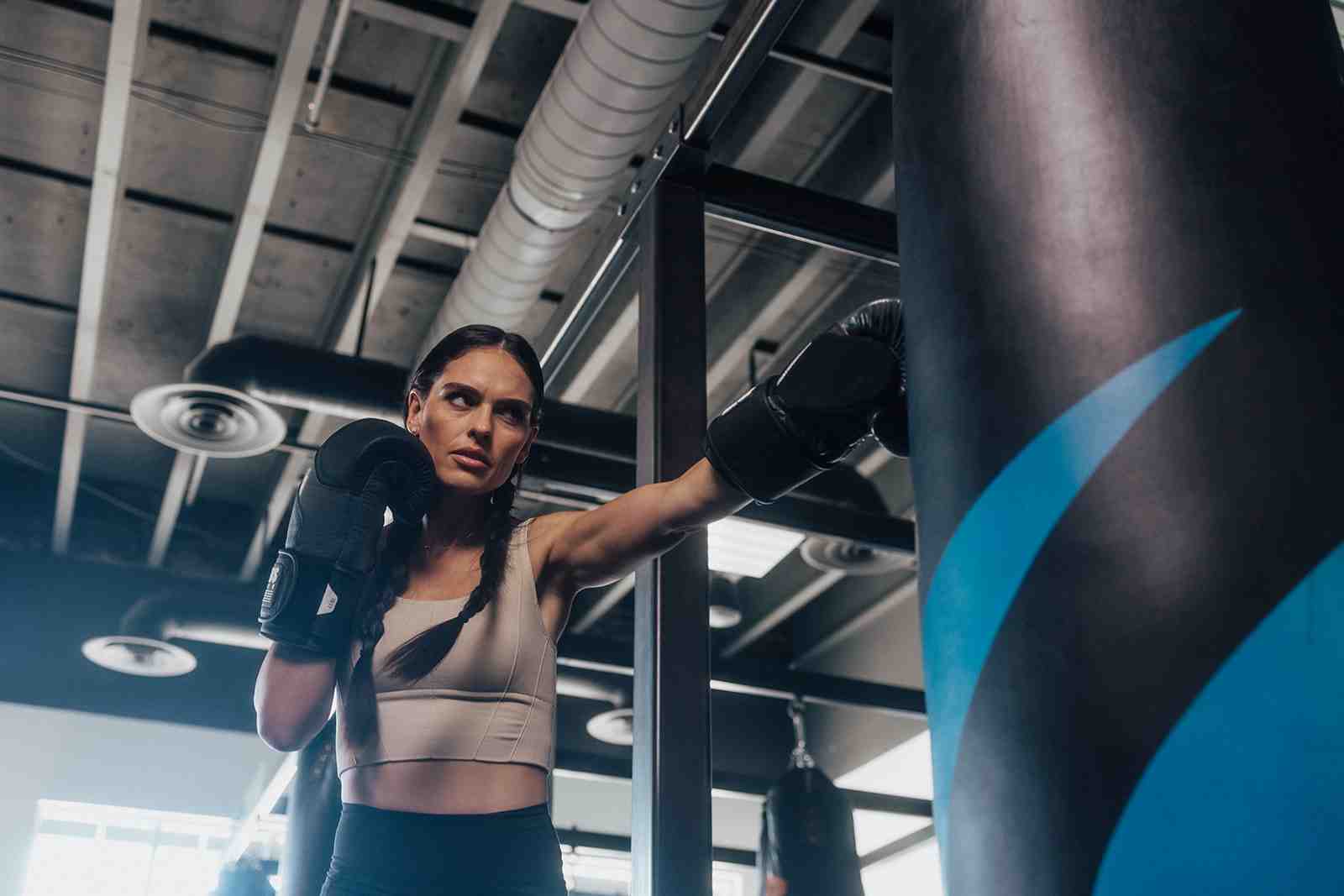woman hitting a heavy bag with proper form - female boxing near me