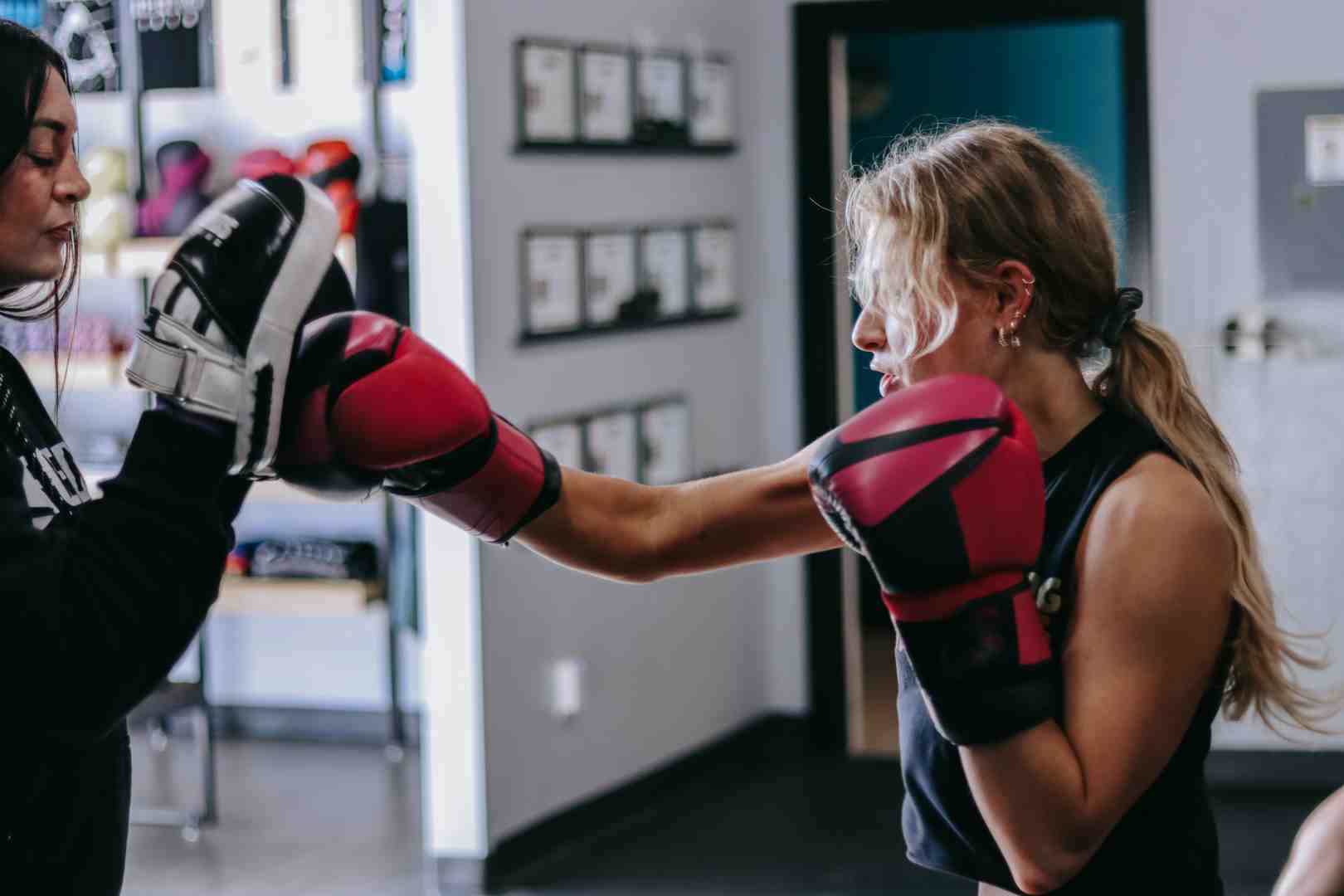 A coach holding focus mitts for a client, demonstrating personalized training - private boxing lessons utah