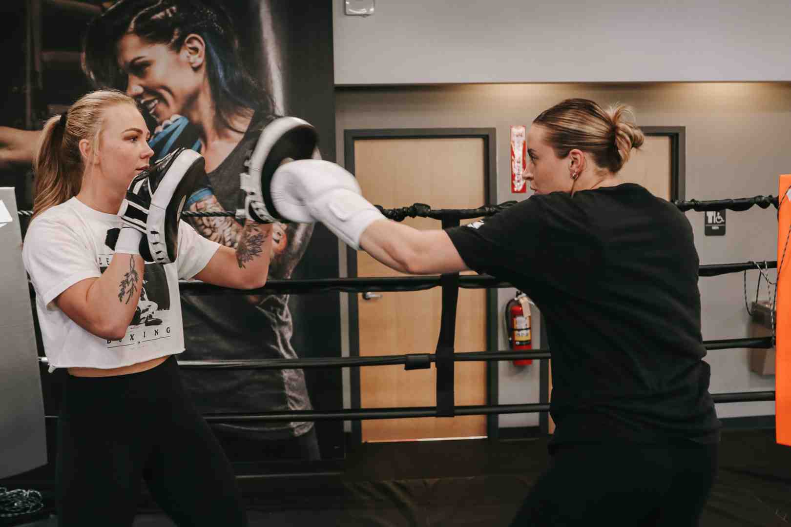 person using training gloves on focus mitts - How to choose boxing gloves