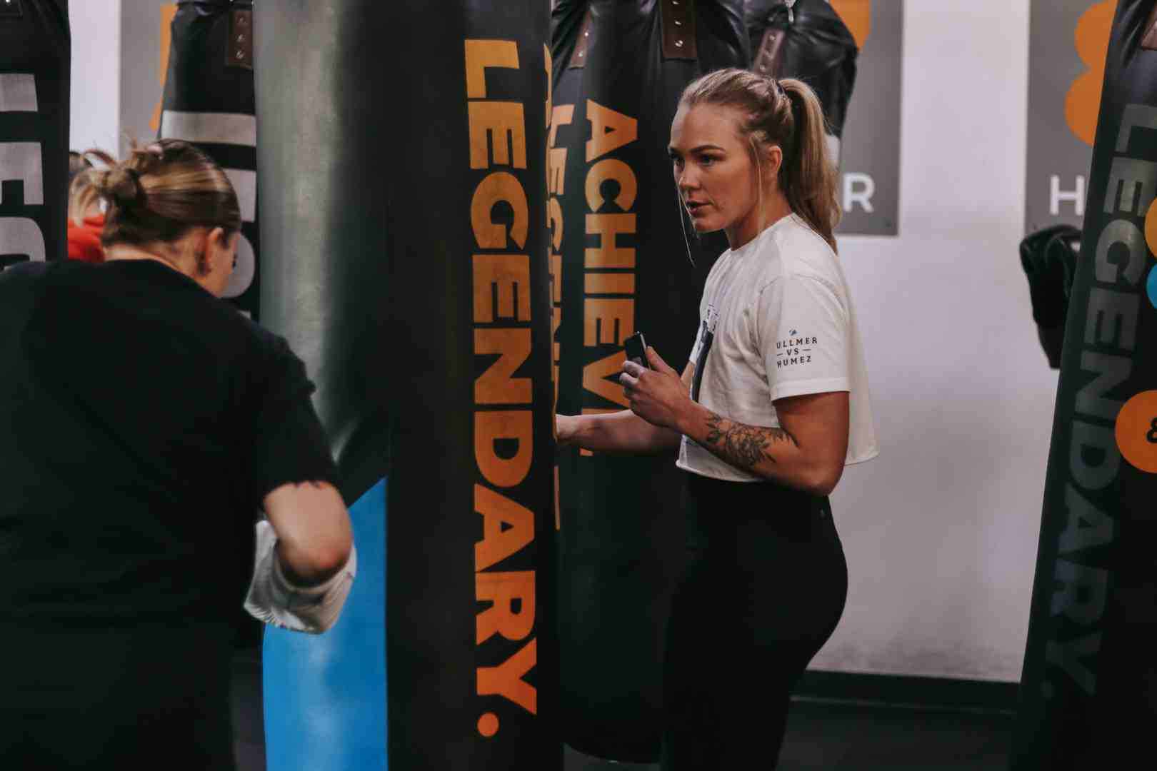 Image of a coach guiding a beginner on the heavy bag - heavy bag circuit