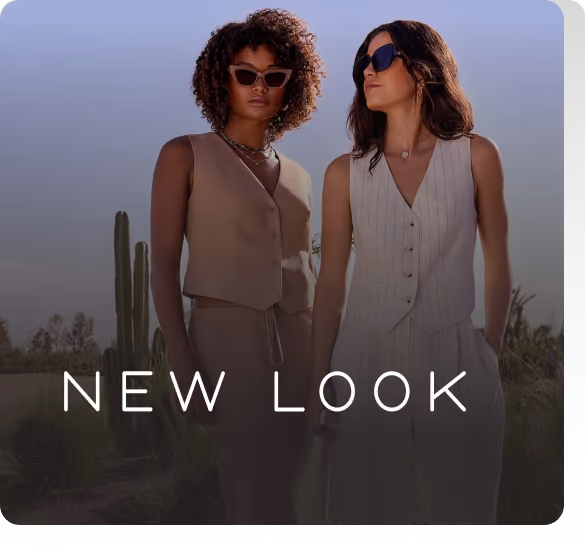 Two women standing in front of a cactus with a sign that says New Look.
