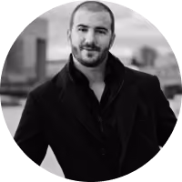 A man wearing a black jacket and a black shirt.