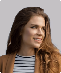 A woman with long hair and a brown jacket smiling.