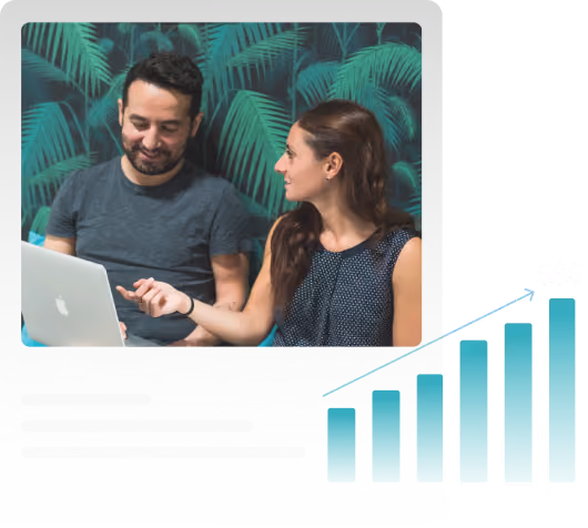 Two people discussing work on a laptop with a rising bar graph illustration nearby.