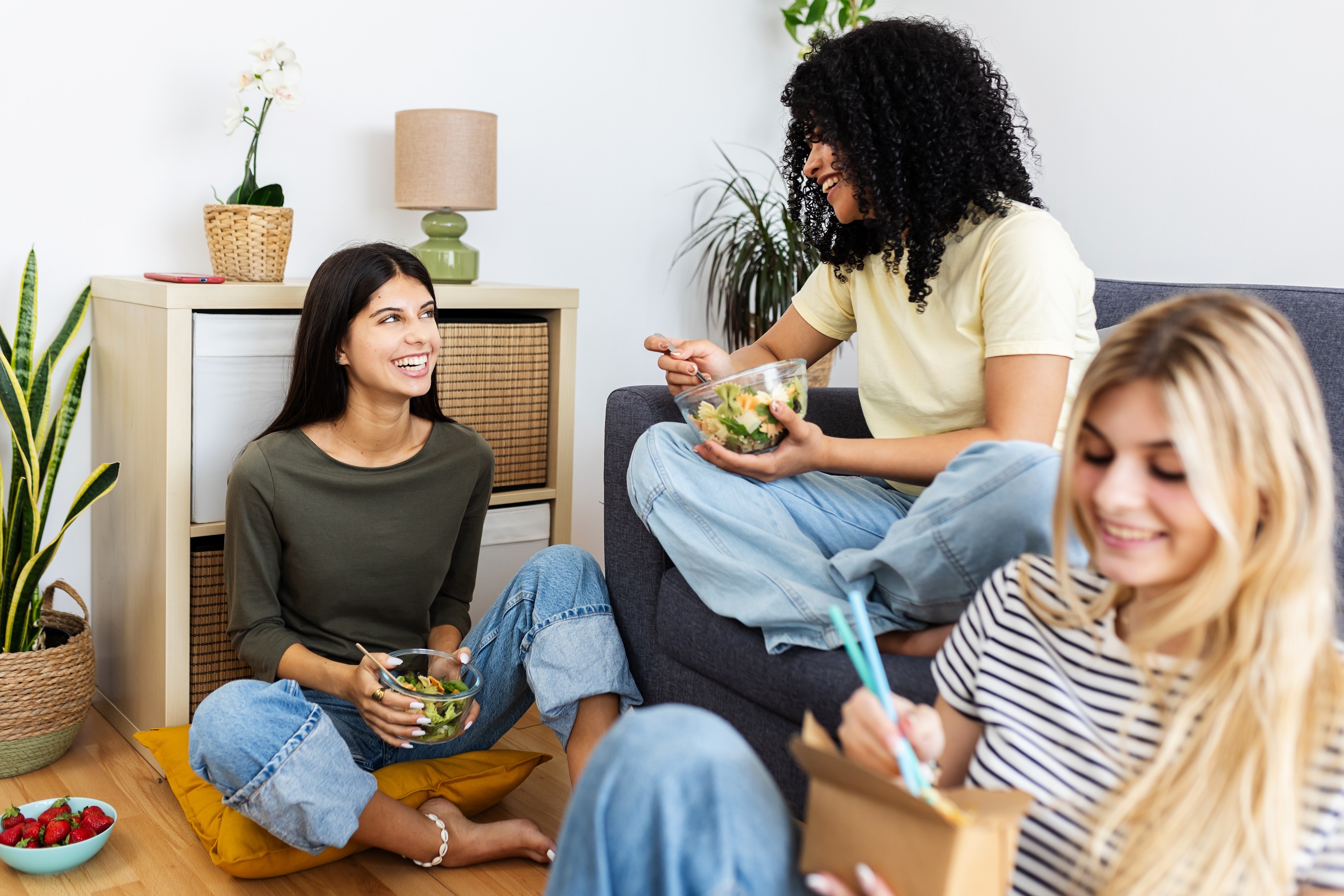 Three Texas A&M student roommates smiling in their fully furnished off-campus apartment in College Station