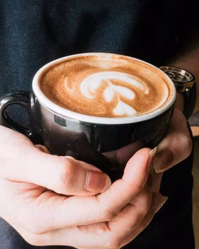 A mug of coffee being held