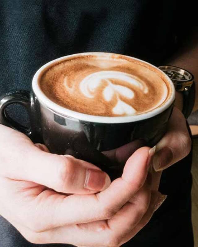 A mug of coffee being held