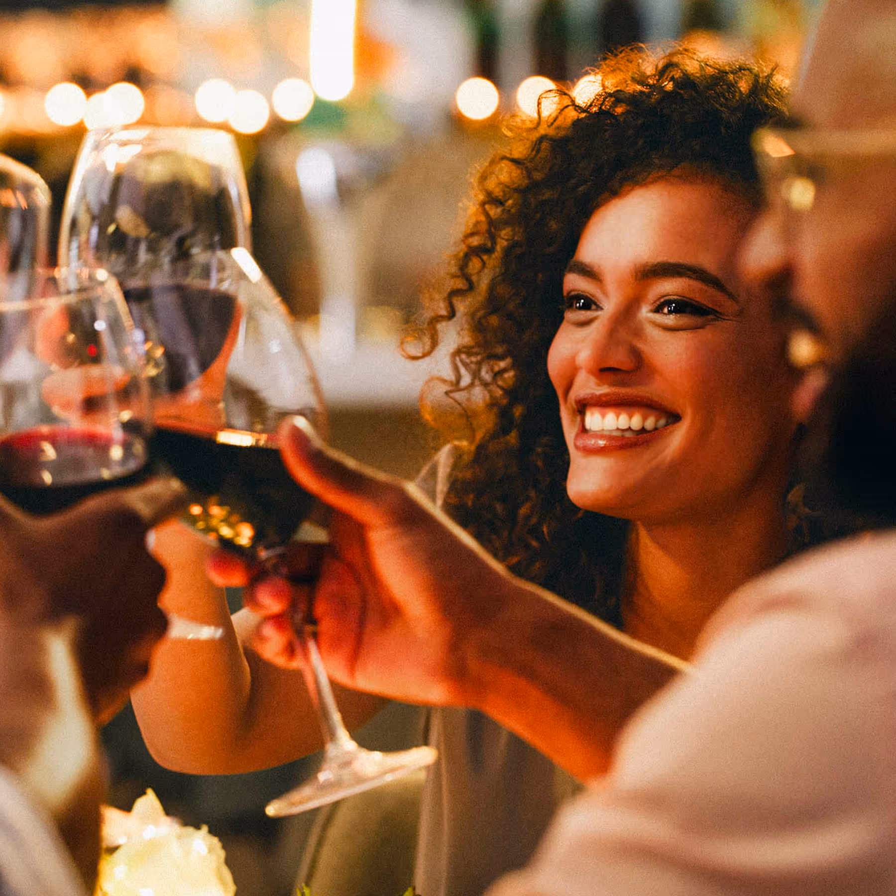 Close up of people cheersing wine glasses
