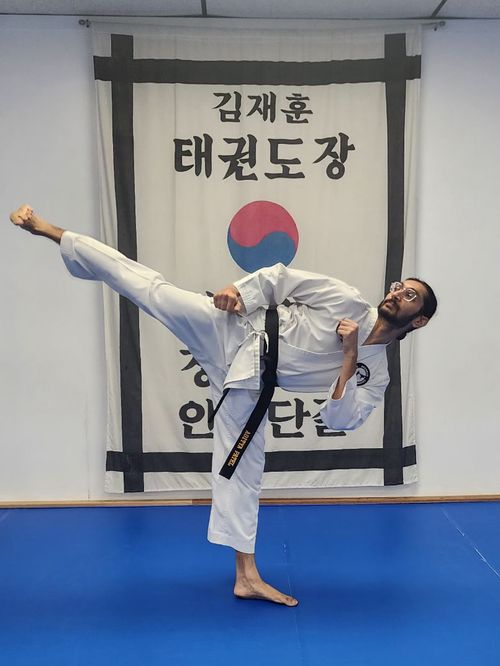 Aditya doing a side kick, while wearing his taekwondo uniform