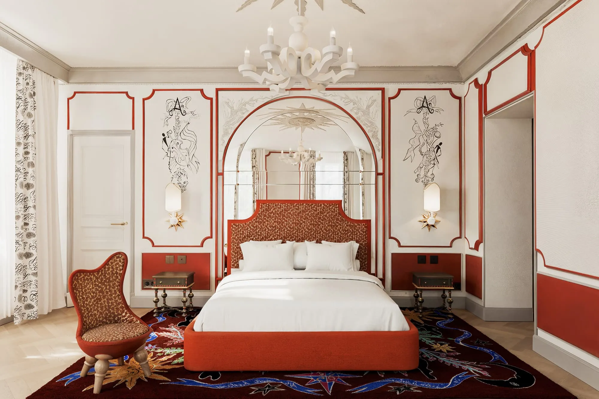 L’Aventure bedroom with a red headboard and matching armchair.