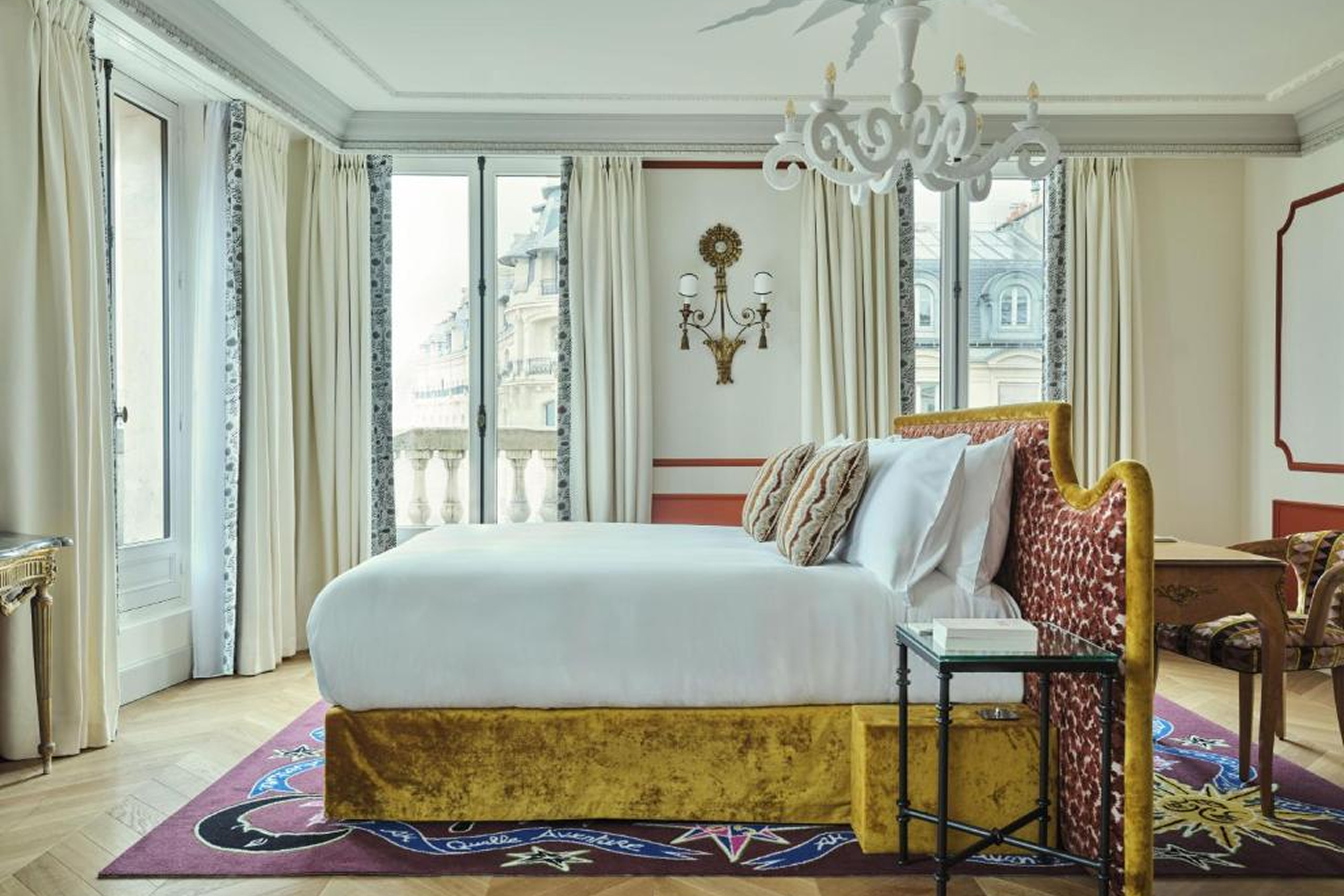 Chambre lumineuse avec lit double et grandes fenêtres à L’Aventure.