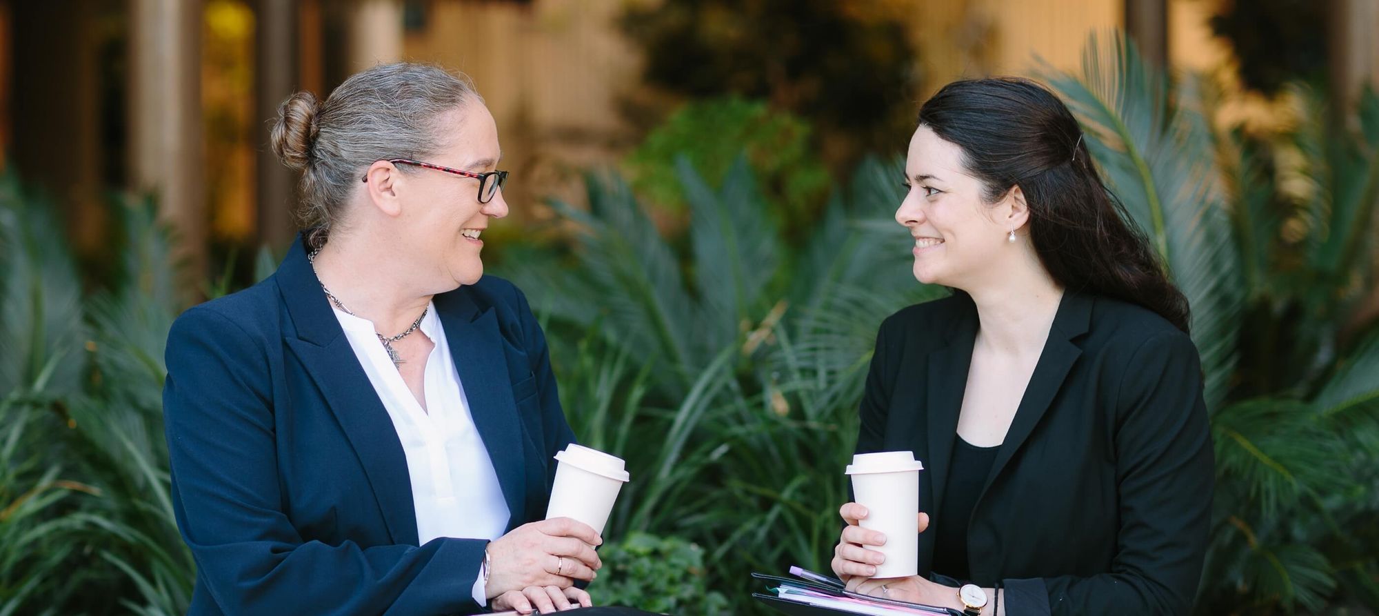 NDIS consultants from HealthQ Consulting discussing NDIS compliance and audit support over coffee in a professional setting.