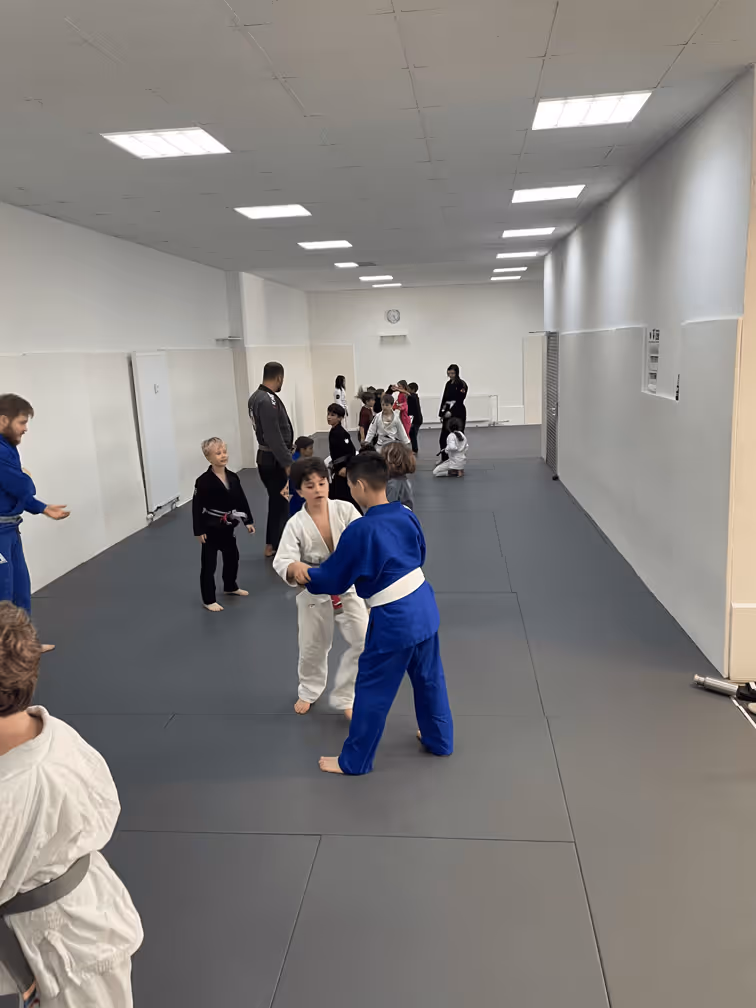 Kinder im Kimono trainieren brasilianisches Jiu-Jitsu in der geräumigen Dream Art Halle.