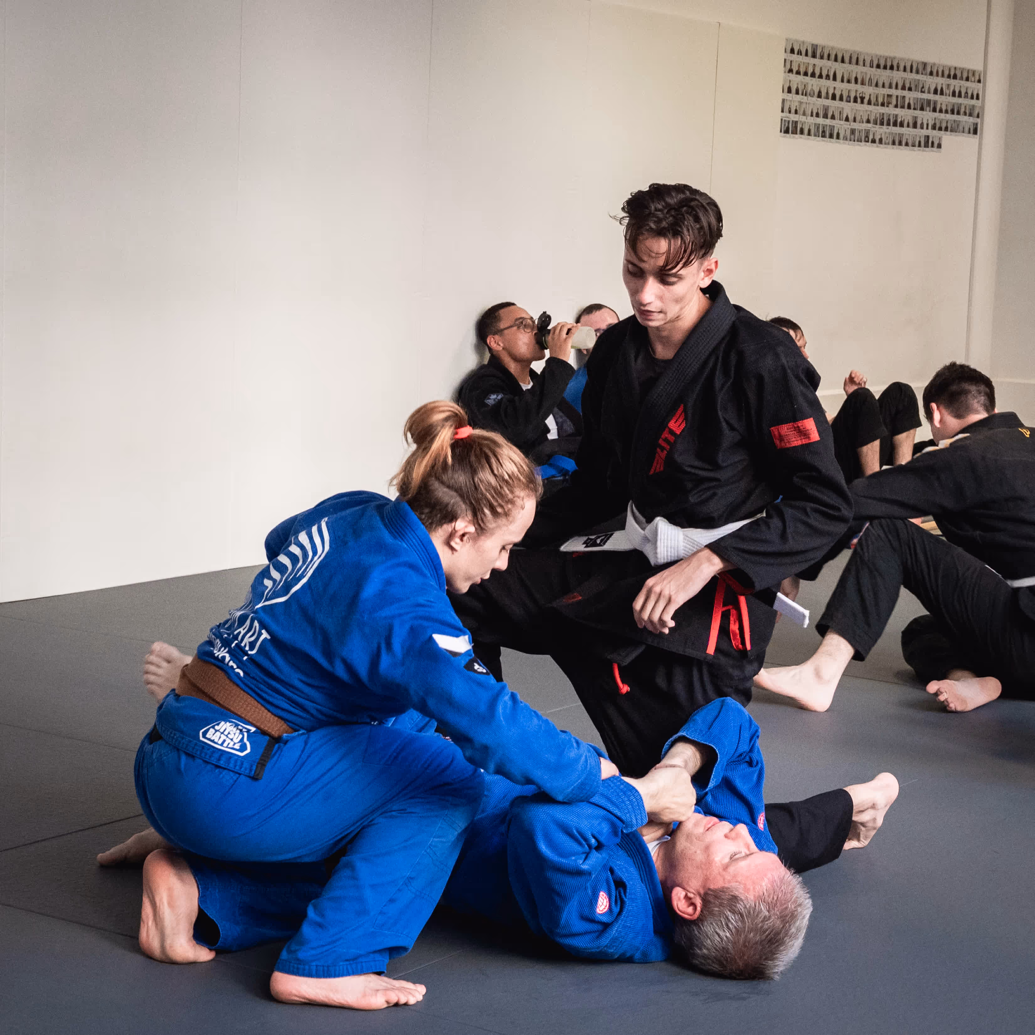 Trainingssession im Dream Art Nürnberg: Ein Trainer leitet eine Gruppe von BJJ-Schülern in blauen und schwarzen Gis an.