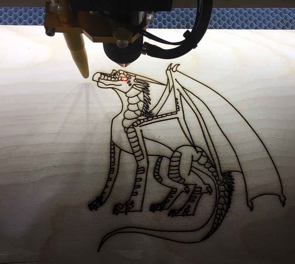 3D printer creating detailed dragon illustration with wings and scales on white surface