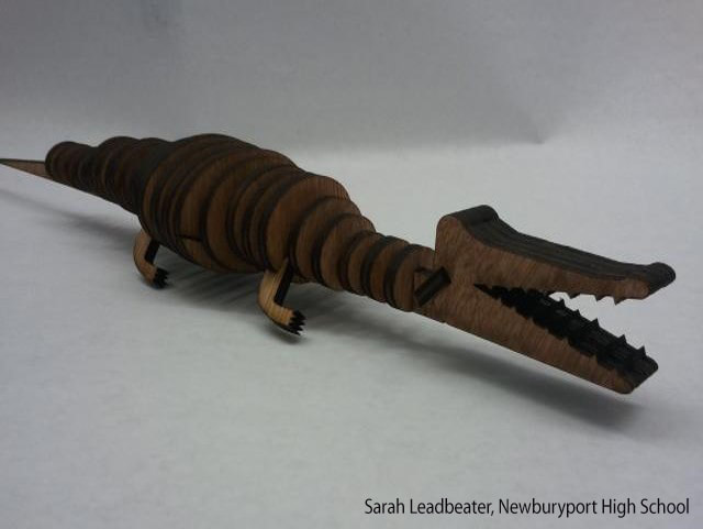 Brown wooden crocodile sculpture with segmented body and open mouth showing teeth.