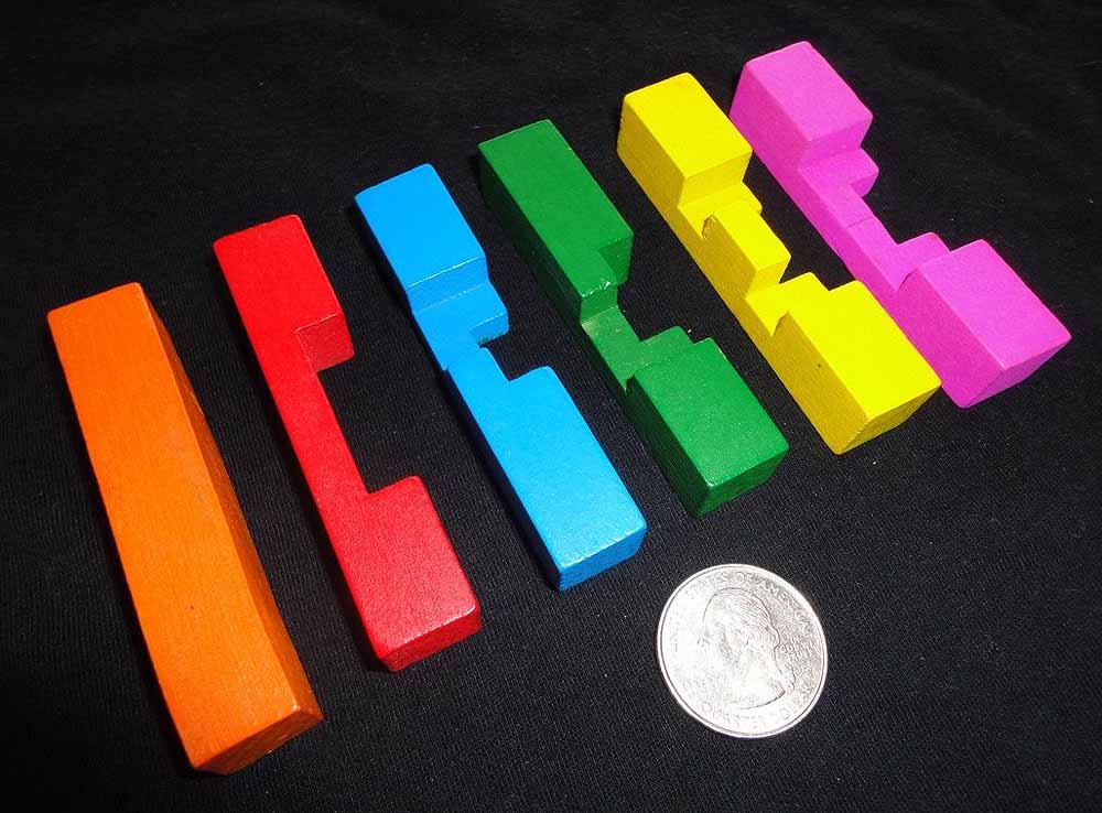 Colorful stacked building blocks in rainbow order with coin for scale comparison.