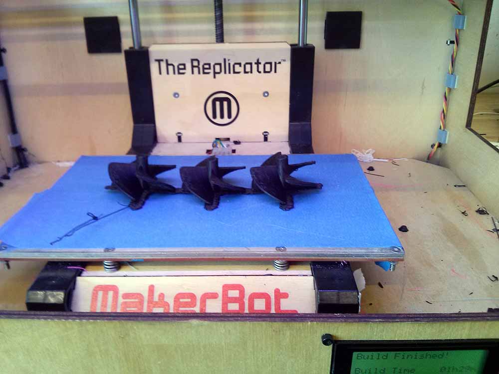 MakerBot 3D printer The Replicator with printed black objects on blue build platform