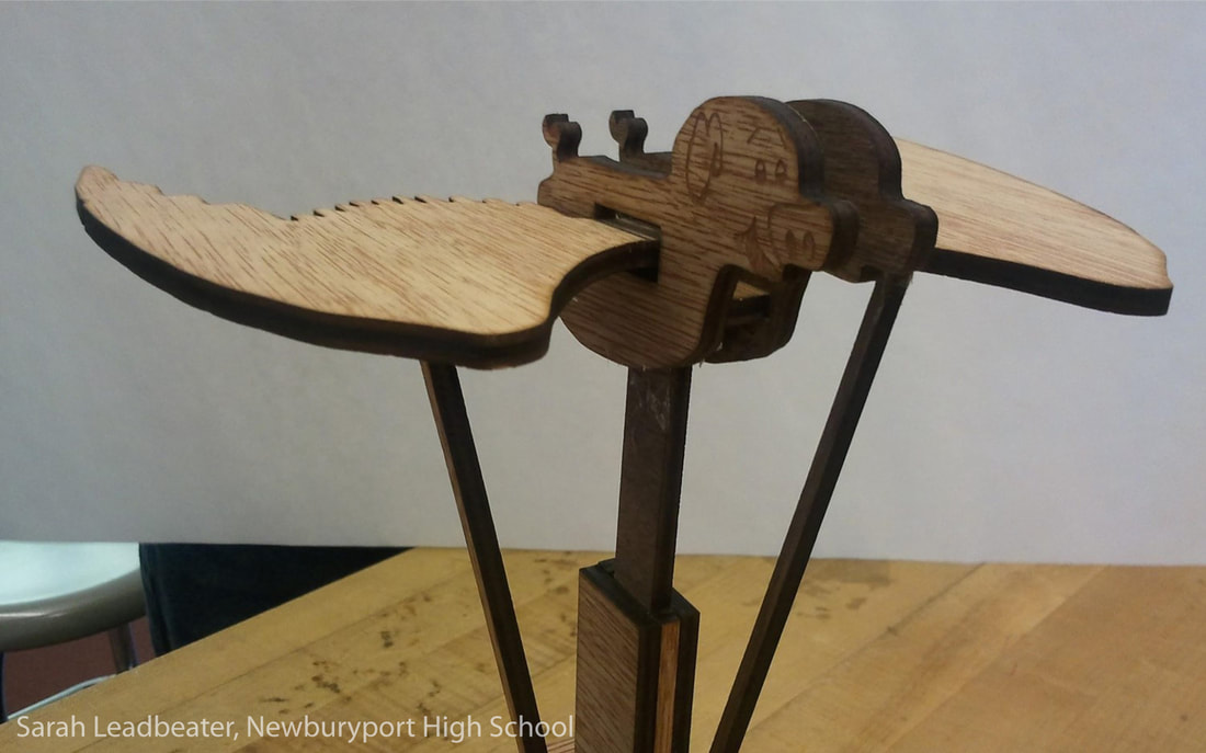 Wooden mechanical clamp device with light and dark wood construction on table