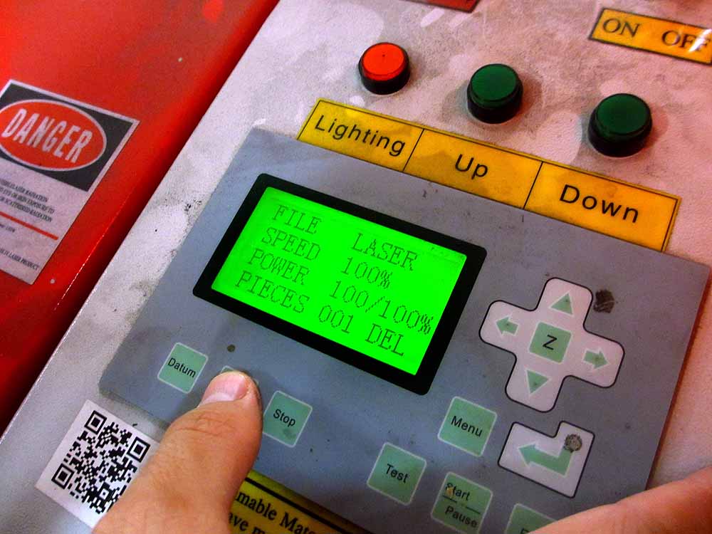 Industrial control panel with green display showing laser parameters and control buttons
