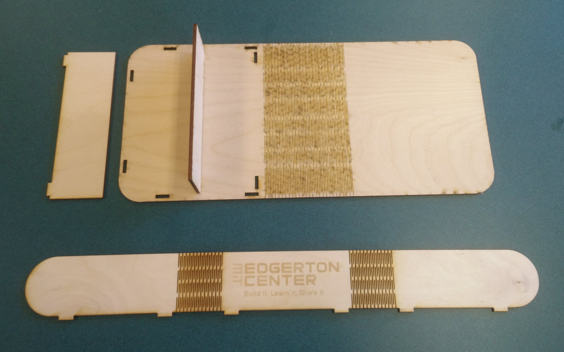Wooden craft pieces and strips with Edgerton Center branding on turquoise background