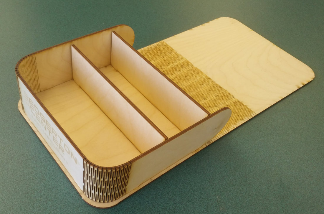 Open cardboard box with dividers and lid on green surface, flat lay view.