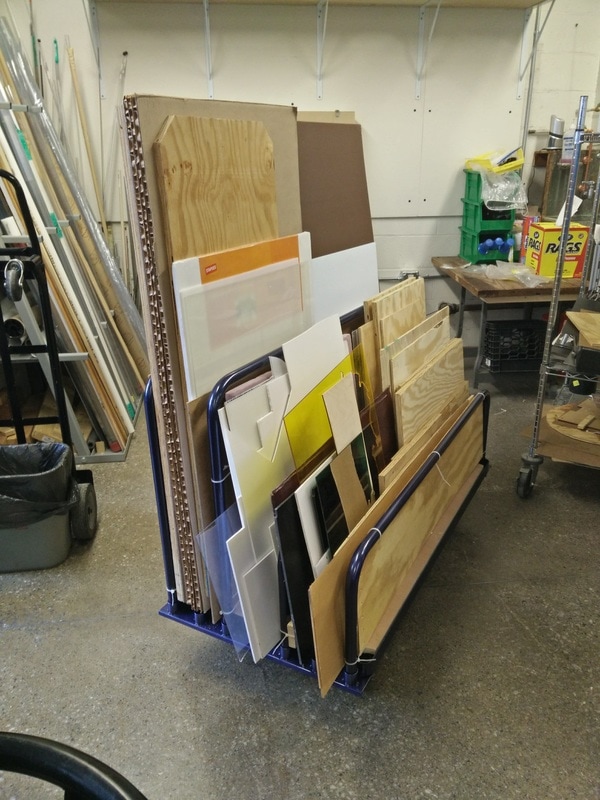 Vertical and rolling racks can be used for rigid sheet materials. This rack made of metal bars has been modified with sheets of plywood to contain smaller pieces.