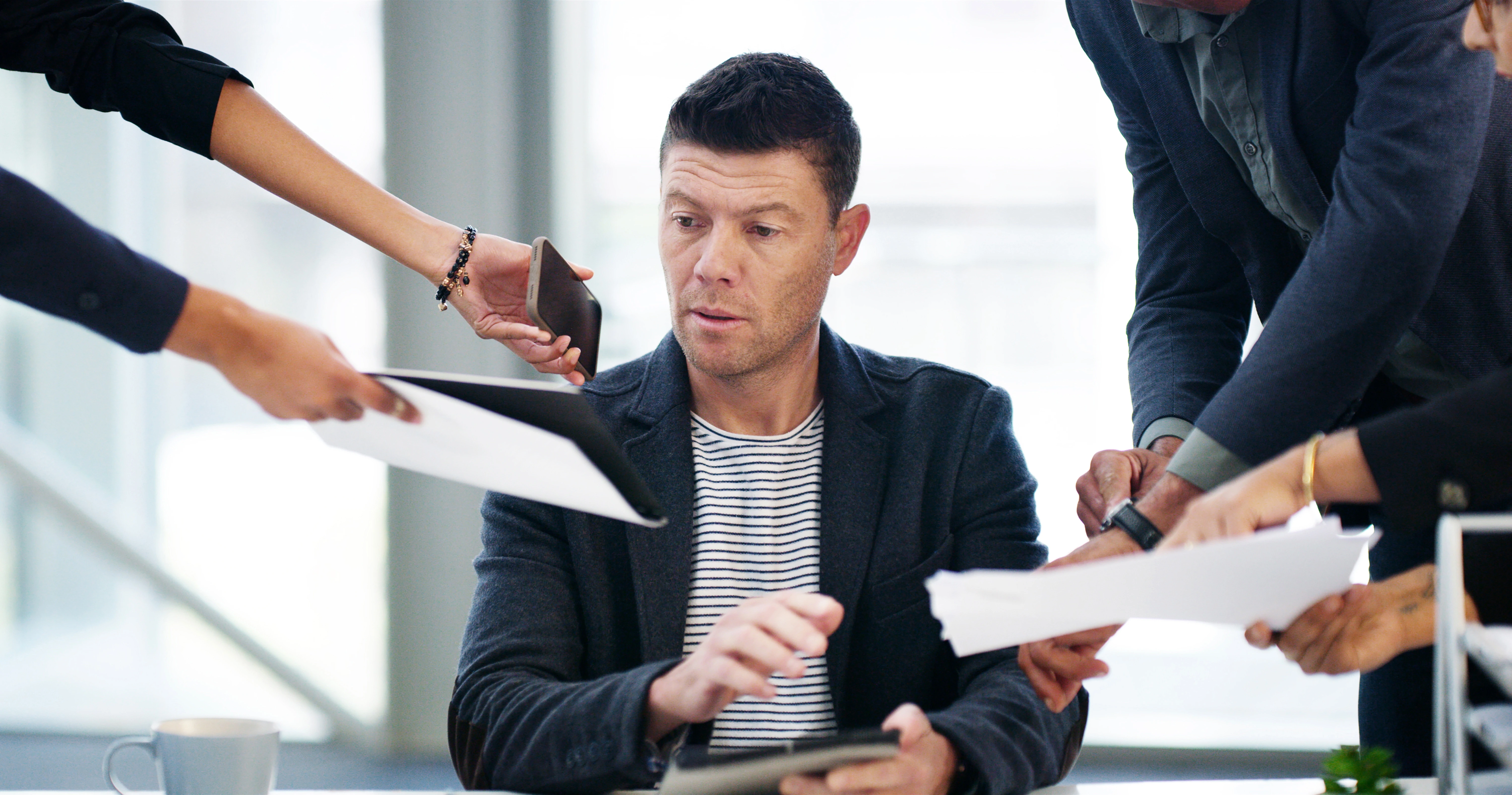 Frustrated communications manager juggling multiple communication channels at work